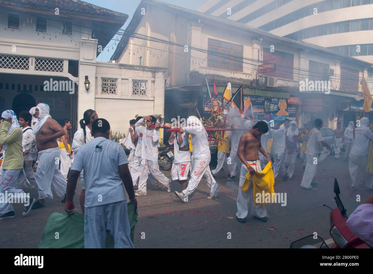 Thaïlande: Les porteurs de sanctuaire font la course dans les rues pour éviter l'explosion des pétards et le bruit assourdissant, Festival végétarien de Phuket. Le Festival végétarien est un festival religieux qui se tient chaque année sur l'île de Phuket dans le sud de la Thaïlande. Il attire des foules de spectateurs en raison de nombreux rituels religieux inhabituels qui sont exécutés. Beaucoup de dévotés religieux se slaleront avec des épées, perce leurs joues avec des objets pointus et commettent d'autres actes douloureux. Banque D'Images