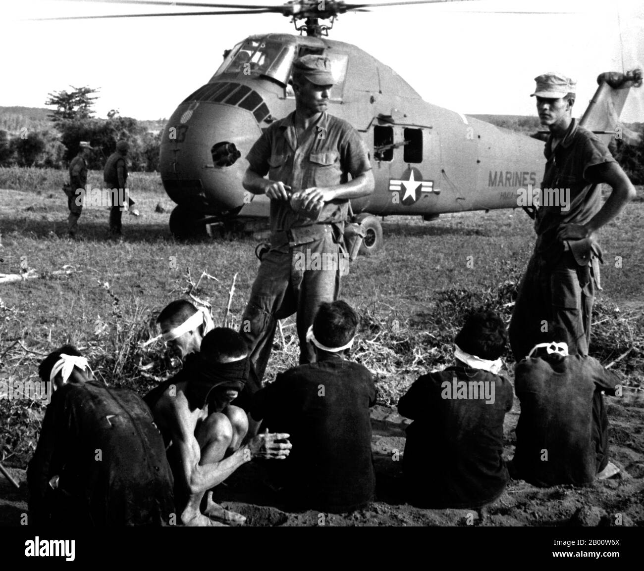 Vietnam : prisonniers présumés de NLF capturés dans l'opération Starlight, une opération de recherche et de destruction du corps des Marines des États-Unis au sud de Chu Lai, août 1965. Opération Starlight, une opération de recherche et de destruction du corps des Marines des États-Unis au sud de Chu Lai. Les victimes de VC ont été au nombre de 599 tuées et six capturées. Les prisonniers Viet Cong attendent d'être transportés par hélicoptère vers la zone arrière. Août 1965. Image de domaine public JUSPAO (USIA). Banque D'Images