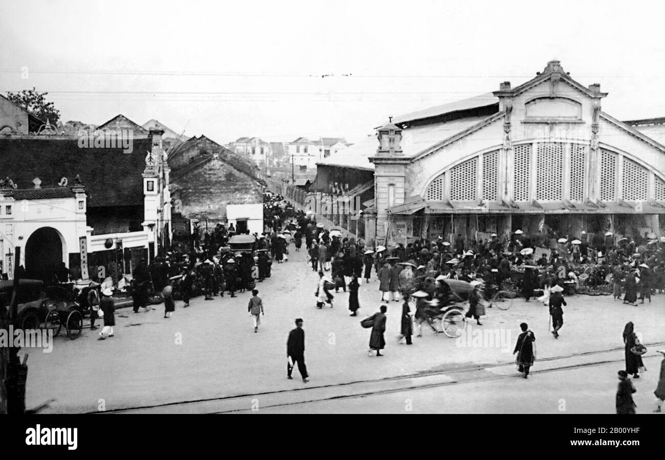 Vietnam : marché de Dong Xuan, Hanoï (début du XXe siècle). Construit à l'origine par l'administration française en 1889 dans le vieux quartier de Hanoï, lorsque les deux principaux marchés de la ville, l'un dans la rue Hang Duong et l'autre dans la rue Hang Ma, ont été fermés. La caractéristique la plus reconnaissable du marché était l'entrée à 5 arcs correspondant aux cinq dômes du marché de Dong Xuan. Le marché de Dong Xuan a été rénové plusieurs fois depuis, le dernier en 1994 après un incendie a presque détruit le marché. Aujourd'hui, le marché de Dong Xuan est le plus grand marché couvert de Hanoi. Banque D'Images