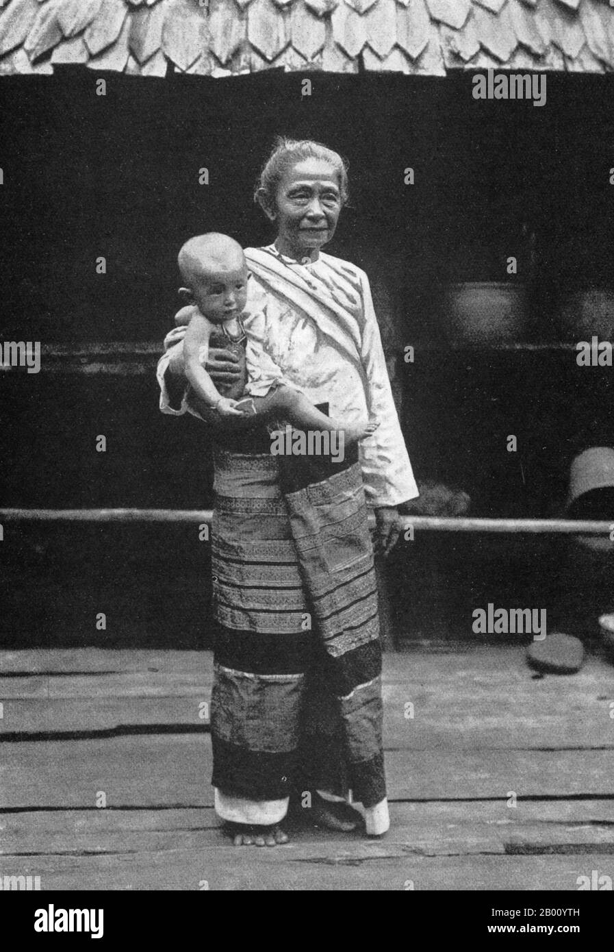 Thaïlande: Une vieille dame du nord de la Thaïlande dans une jupe traditionnelle élaborée avec son petit-enfant, début du XXe siècle. L'histoire du nord de la Thaïlande est dominée par le Royaume de Lanna, qui a été fondé en 1259 par le roi Mangrai et est resté une force indépendante jusqu'au XVIe siècle. Une grande partie du nord de la Thaïlande est montagneuse. Banque D'Images