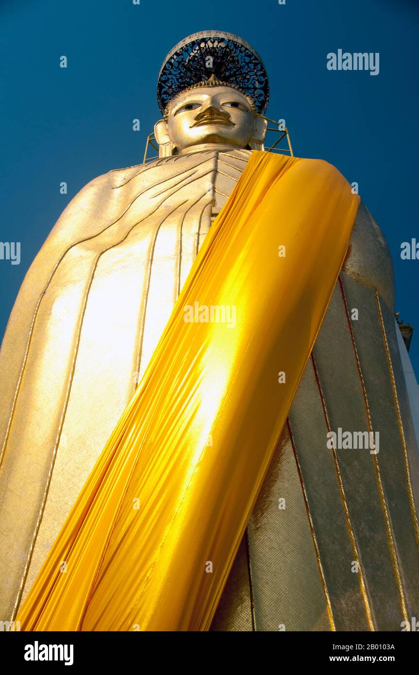 Thaïlande: Bouddha géant, Wat Intharawihan, Bangkok. La caractéristique principale du Wat Intharawihan de Bangkok est le Bouddha de 32 mètres de haut appelé Luang Pho ou Phrasiariyametri. Il a fallu plus de 60 ans pour terminer et est décoré dans des mosaïques de verre et 24-carats d'or. Le nœud supérieur de l'image de Bouddha contient une relique de Bouddha amené du Sri Lanka. Le temple a été construit au début de la période Ayutthaya. Banque D'Images