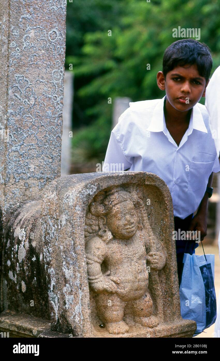 Sri Lanka: Garçon avec soulagement nain, Anuradhapura. Anuradhapura est l'une des anciennes capitales du Sri Lanka et célèbre pour ses ruines bien conservées. Du 4ème siècle avant notre ère jusqu'au début du XIe siècle avant notre ère c'était la capitale. Pendant cette période, il est resté l'un des centres de pouvoir politique et de vie urbaine les plus stables et les plus durables d'Asie du Sud. La ville antique, considérée sacrée pour le monde bouddhiste, est aujourd'hui entourée de monastères couvrant une superficie de plus de seize miles carrés (40 km²). Banque D'Images