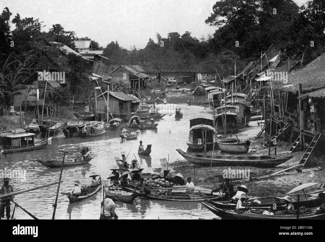 Thaïlande: Une scène de canal de Bangkok à marée basse, c. 1900. Au tournant du XXe siècle, la grande majorité des Siamois étaient des riziculteurs qui vivaient et travaillaient le long des cours d'eau. Chaque ménage avait un bateau, dont environ 600,000 navigué sur les canaux et les rivières de Bangkok. L'aviron a été fait de l'arrière du bateau. La plupart des maisons étaient en bois et en bambou, et ont été construites sur pilotis avec une échelle allant à l'eau. Banque D'Images