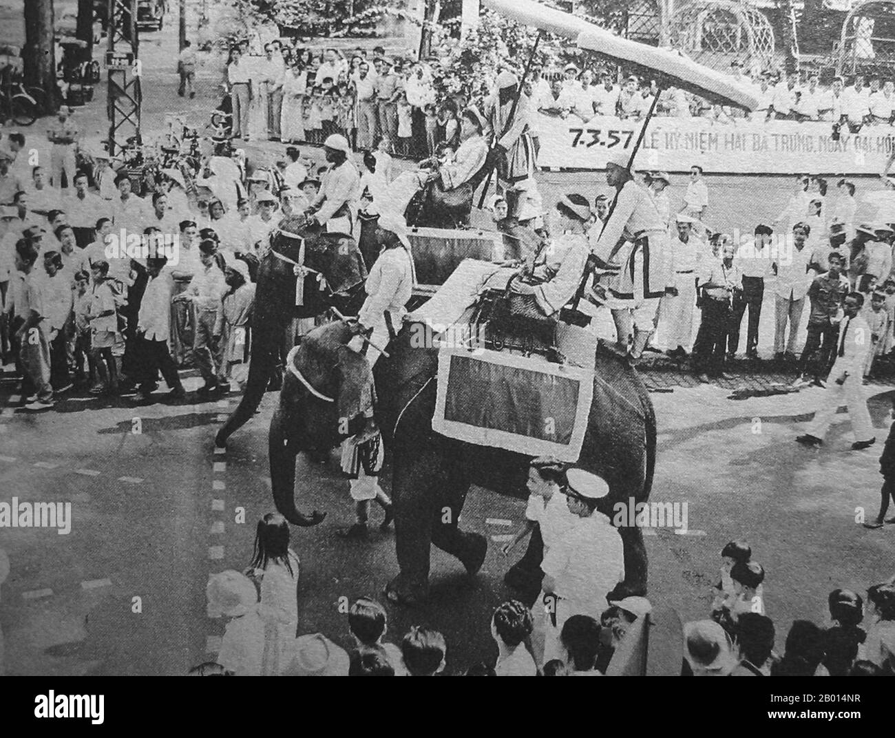 Vietnam : défilé des Sœurs de Trung (Hai Ba Trung) à Saigon, 26 avril 1957. Deux vietnamiennes à dos d'éléphant représentent les célèbres Sœurs Trung (Hai Ba Trung) dans la parade Hai Ba Trung annuelle, Saigon, 26 avril 1957. Les Sœurs Trưng (c. 12 - 43 ce), connu en vietnamien sous le nom de Hai Bà Trưng (littéralement les deux Trưng Ladies), et individuellement sous le nom de Trưng Trắc et Trưng Nhị, étaient deux femmes leaders vietnamiens du premier siècle qui se sont rebellés avec succès contre la dynastie chinoise Han pendant trois ans, et sont considérées comme des héroïnes nationales du Vietnam. Banque D'Images