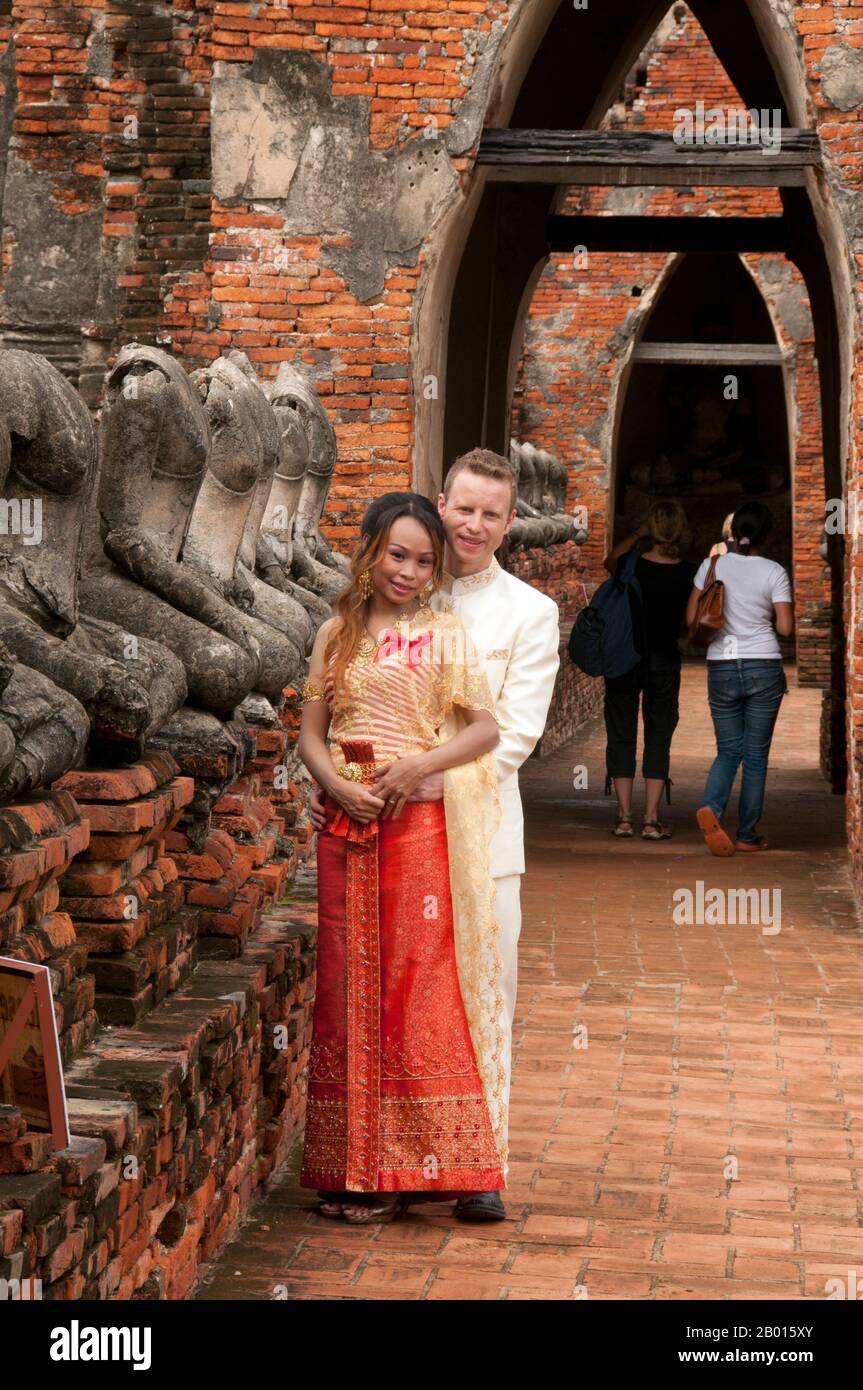 Thaïlande: Un jeune couple posant pour leurs photos de mariage, Wat Chai Wattanaram, Parc historique d'Ayutthaya. Wat Chai Wattanaram (Watthanaram) wad construit au XVIIe siècle sous le règne du roi Prasat Thong (r. 1629-1656), qui fut le premier roi de la dynastie Prasat Thong. Il est construit beaucoup dans le style Angkor/Khmer. Ayutthaya (Ayudhya) était un royaume siamois qui existait de 1351 à 1767. Ayutthaya était amical envers les commerçants étrangers, y compris les Chinois, les Vietnamiens (Annamais), les Indiens, les Japonais et les Perses, Et plus tard, les puissances européennes, leur permettant d'installer des villages à l'extérieur Banque D'Images