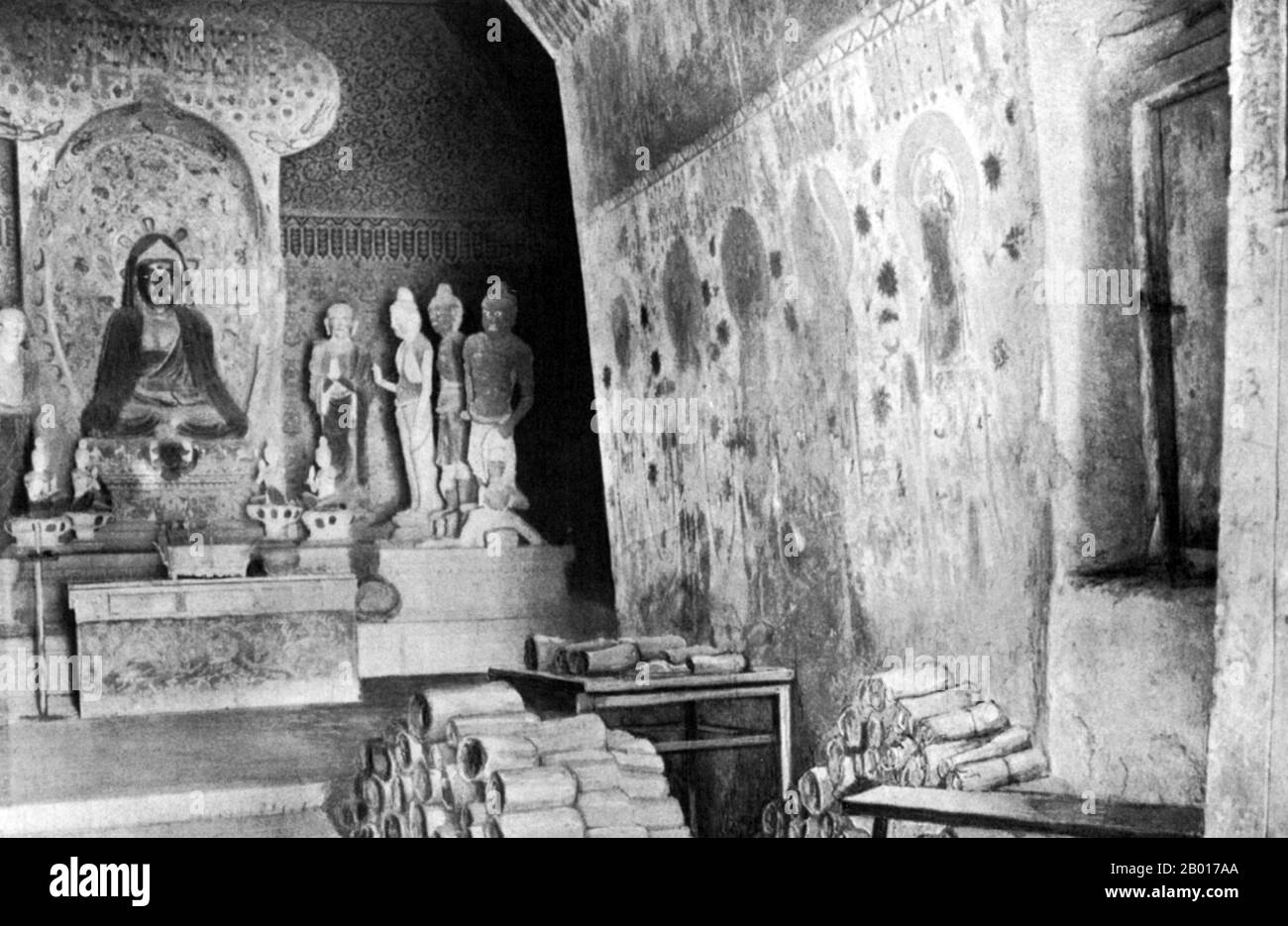 Chine : documents de Cave 17, Mogao, empilés pour examen par Sir Aurel Stein.Dunhuang, 1908.Au début de 1900s, un Daoïste chinois, Wang Yuanlu, s'est nommé gardien de certaines des grottes de Mogao.Wang a découvert une zone fortifiée derrière un côté d'un couloir menant à une grotte principale.Derrière le mur se trouvait une petite grotte bourrée d'un énorme panier de manuscrits datant de 406 à 1002 ce.Il s'agit notamment de vieux rouleaux de papier de chanvre en chinois et dans de nombreuses autres langues, de peintures sur le chanvre, la soie ou le papier, de nombreuses figurines endommagées de Bouddhas, et d'autres paraphhernalia bouddhistes. Banque D'Images