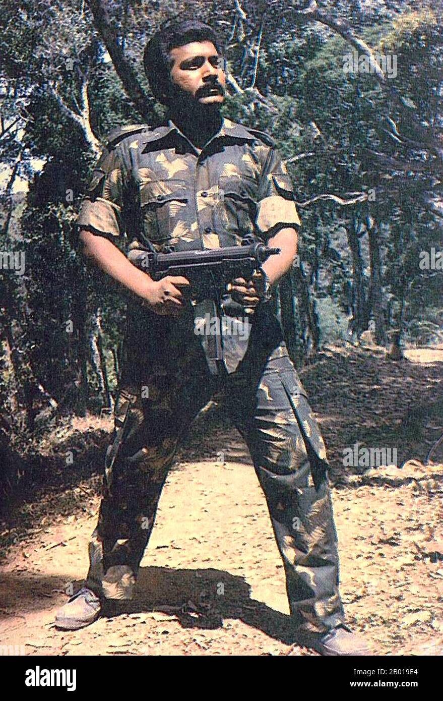 Sri Lanka: LTTE Comander Velupillai Prabhakaran (26 novembre 1954 - 18 mai 2009) posant avec une mitrailleuse quelque part dans le Wanni, dans le nord du Sri Lanka, c. 1985. Velupillai Prabhakaran était le fondateur et le chef des Tigres de libération de l'Eelam tamoul (les LTTE ou les Tigres tamouls), une organisation militante qui cherchait à créer un État tamoul indépendant dans le nord et l'est du Sri Lanka. Pendant plus de 25 ans, les LTTE ont mené une violente campagne sécessionniste au Sri Lanka qui l'a désignée organisation terroriste par 32 pays. Banque D'Images