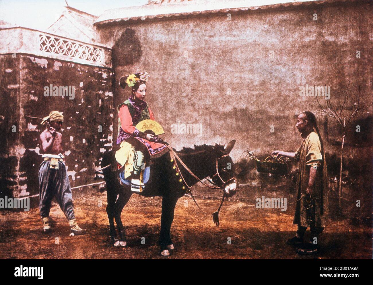 Chine : une femme de sa finerie de Qing prend un âne, photo de la fin de la dynastie de Qing, éventuellement de John Thomson (1837-1921) ou Lai Along (1839-1890), 1887. Dans cette photo posée avec soin, la femme semble habillée comme une mariée se préparant à monter à son mariage. Banque D'Images
