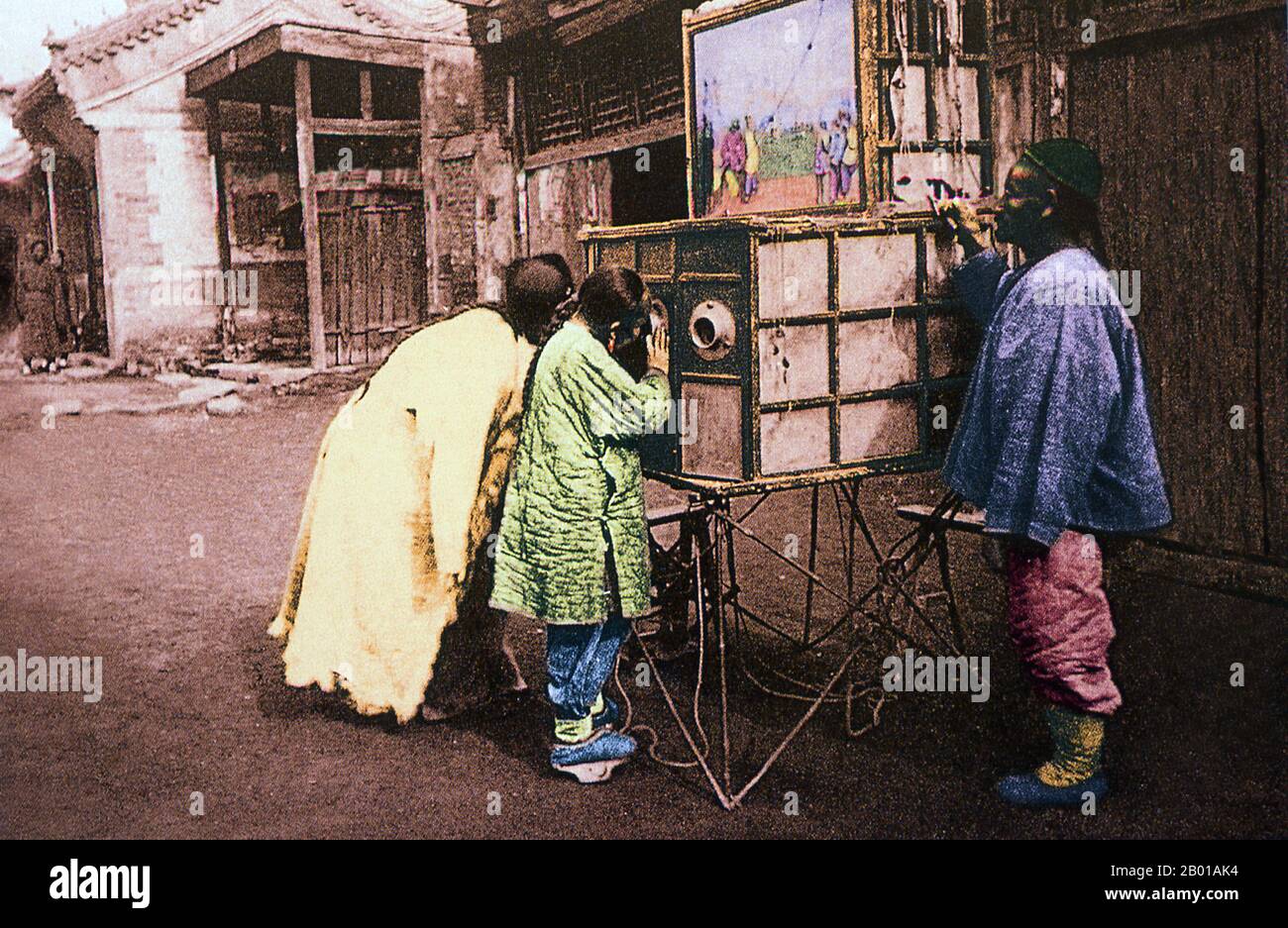 Chine: Enfants regardant un salon de peepshow mobile, Pékin. Photo de John Thomson (13 juin 1837 - 29 septembre 1921), ch. 1869. Un spectacle de peep ou de peepshow est une exposition d'images, d'objets ou de personnes vues à travers un petit trou ou une loupe. Les spectacles de peep chinois du siècle 19th étaient connus par de nombreux noms, y compris la yang p'ien ('tilling étranger Picture cards'). Parfois, le showman se réalisait pour une foule avec des marionnettes ou des photos à l'extérieur de la boîte et facturait des gens supplémentaires pour regarder à travers les trous. Banque D'Images