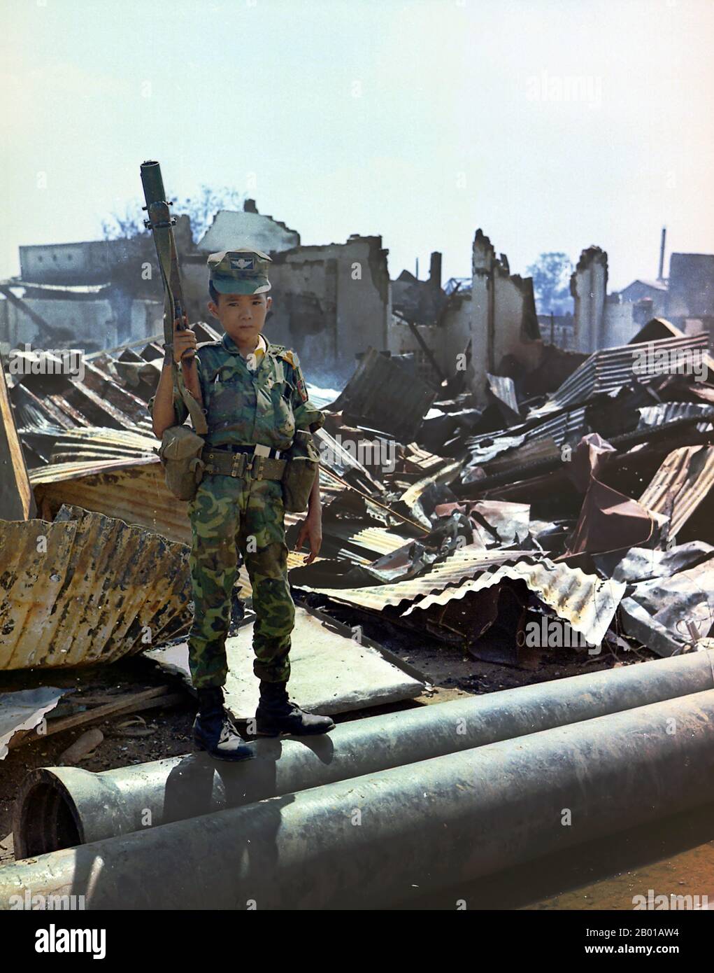 Vietnam : un enfant soldat de 12 ans dans l'uniforme de l'Armée de la République du Vietnam (ARVN), aéroport de Tan son Nhut, Saigon, 7 mai 1968. Un soldat vietnamien ARVN Airborne de douze ans qui avait été "adopté" par la division Airborne, tenant un lanceur de grenade M-79. La photo a été prise lors d'un balayage d'une unité de la Force opérationnelle aéroportée à travers la zone dévastée entourant le cimetière national français sur Plantation Road après une longue bataille là-bas. Banque D'Images