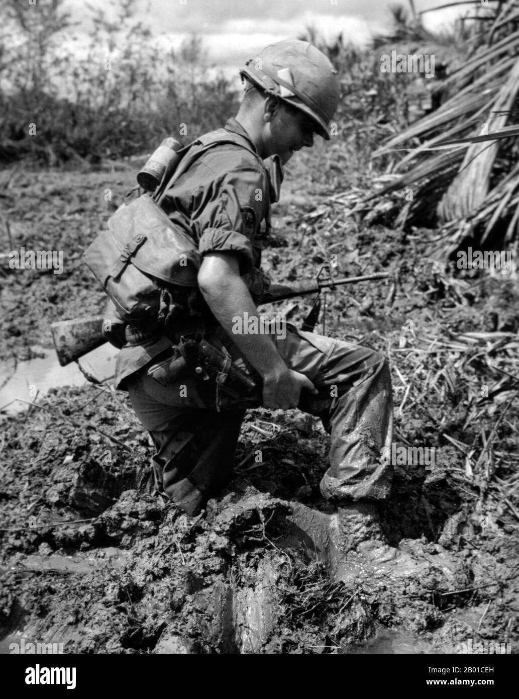 Vietnam: Un fantassin de l'armée américaine s'est enlisé dans la boue du delta du Mékong, c. 1966. La deuxième guerre d'Indochine, connue en Amérique sous le nom de guerre du Vietnam, était un conflit militaire de l'époque de la Guerre froide qui s'est produit au Vietnam, au Laos et au Cambodge du 1 novembre 1955 à la chute de Saigon le 30 avril 1975. Cette guerre a suivi la première Guerre d'Indochine et a été menée entre le Nord du Vietnam, soutenu par ses alliés communistes, et le gouvernement du Sud Vietnam, soutenu par les États-Unis et d'autres nations anticommunistes. Le gouvernement américain considérait l'implication dans la guerre comme un moyen d'empêcher une prise de pouvoir communiste. Banque D'Images