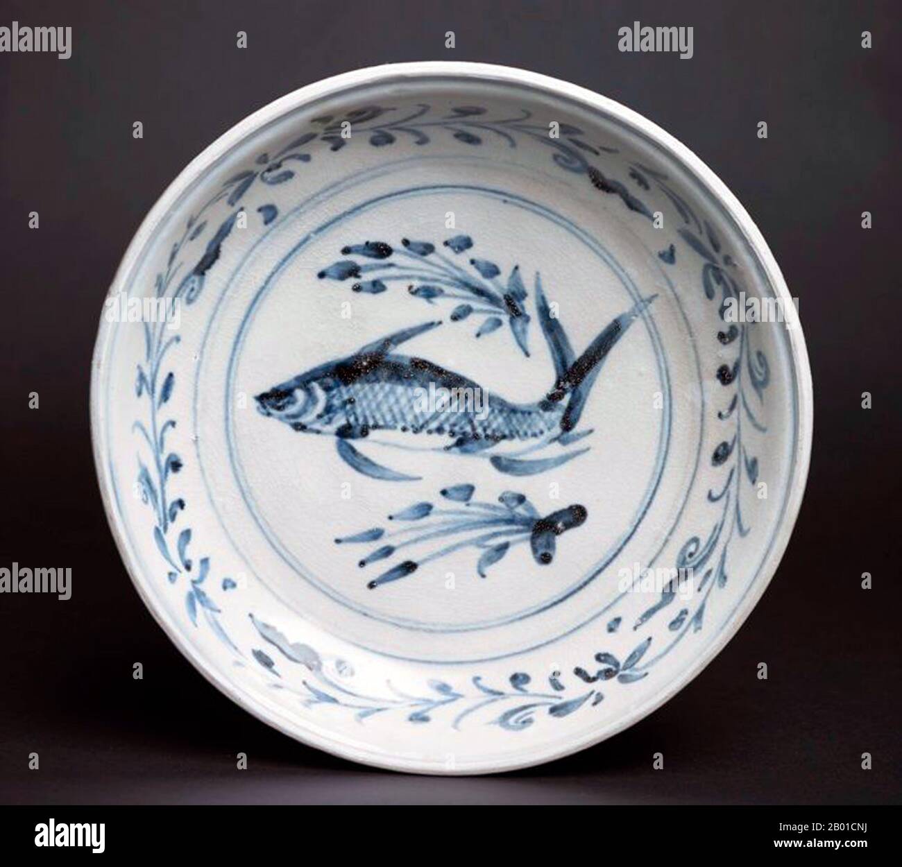 Vietnam: Assiette de poissons bleu et blanc avec un seul poisson nageant parmi les plantes aquatiques, dans une bande de Lotus à défilement. Plus tard, la dynastie Lê (1533-1788). La porcelaine et la poterie de Bát Tràng sont des céramiques fabriquées dans le village de Bát Tràng, à la périphérie de la ville vietnamienne du nord de Hanoï. Le village est situé dans une zone riche en argile pour la fabrication de céramiques fines. Les céramiques de Bát Tràng sont considérées comme certains des produits de porcelaine les plus connus au Vietnam en plus de ceux de Chu Đậu, Đồng Nai, Phu Lang, et Ninh Thuận. Banque D'Images