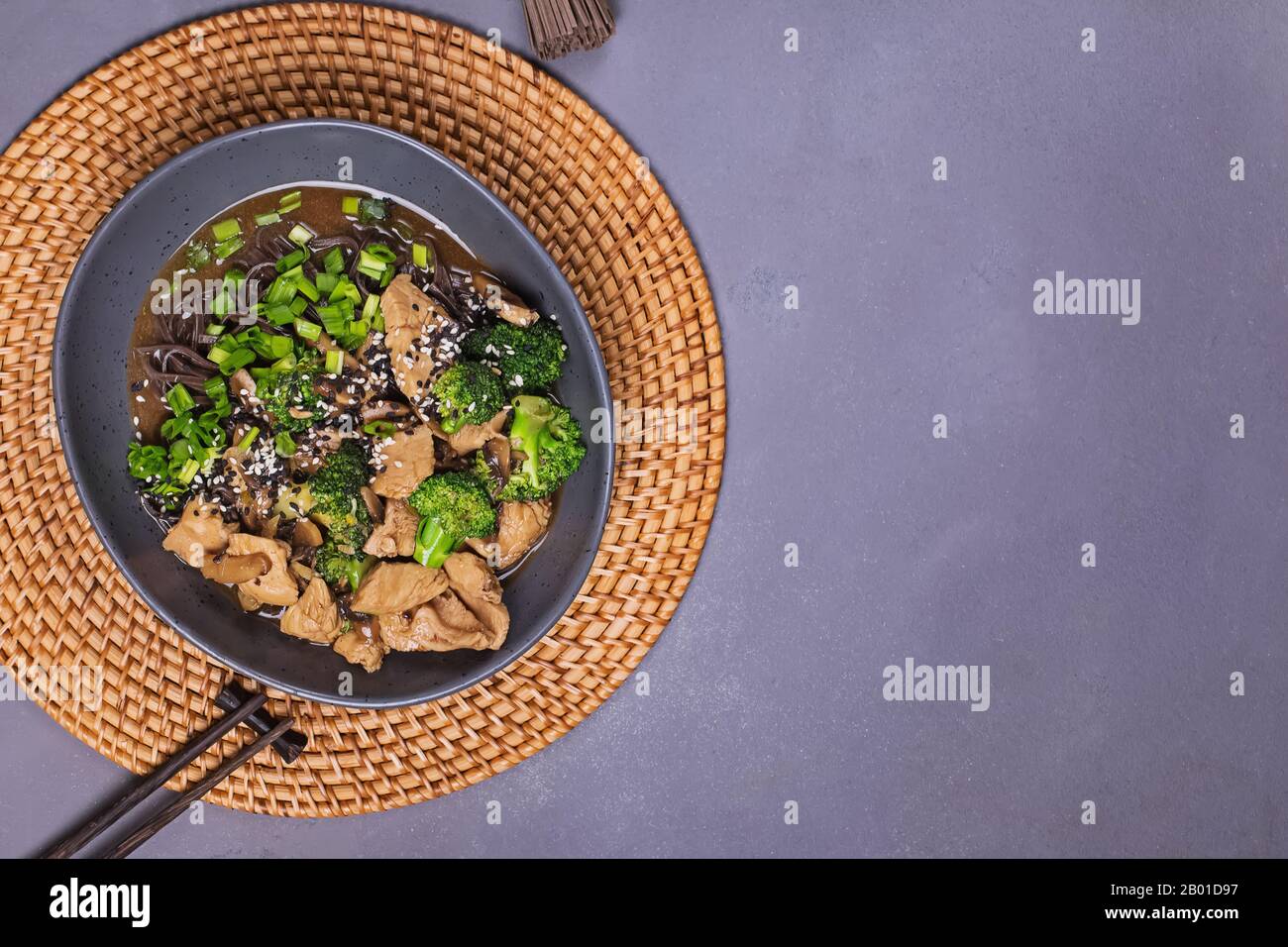 Soba nouilles avec poulet teriyaki et brocoli sur table en pierre grise Banque D'Images