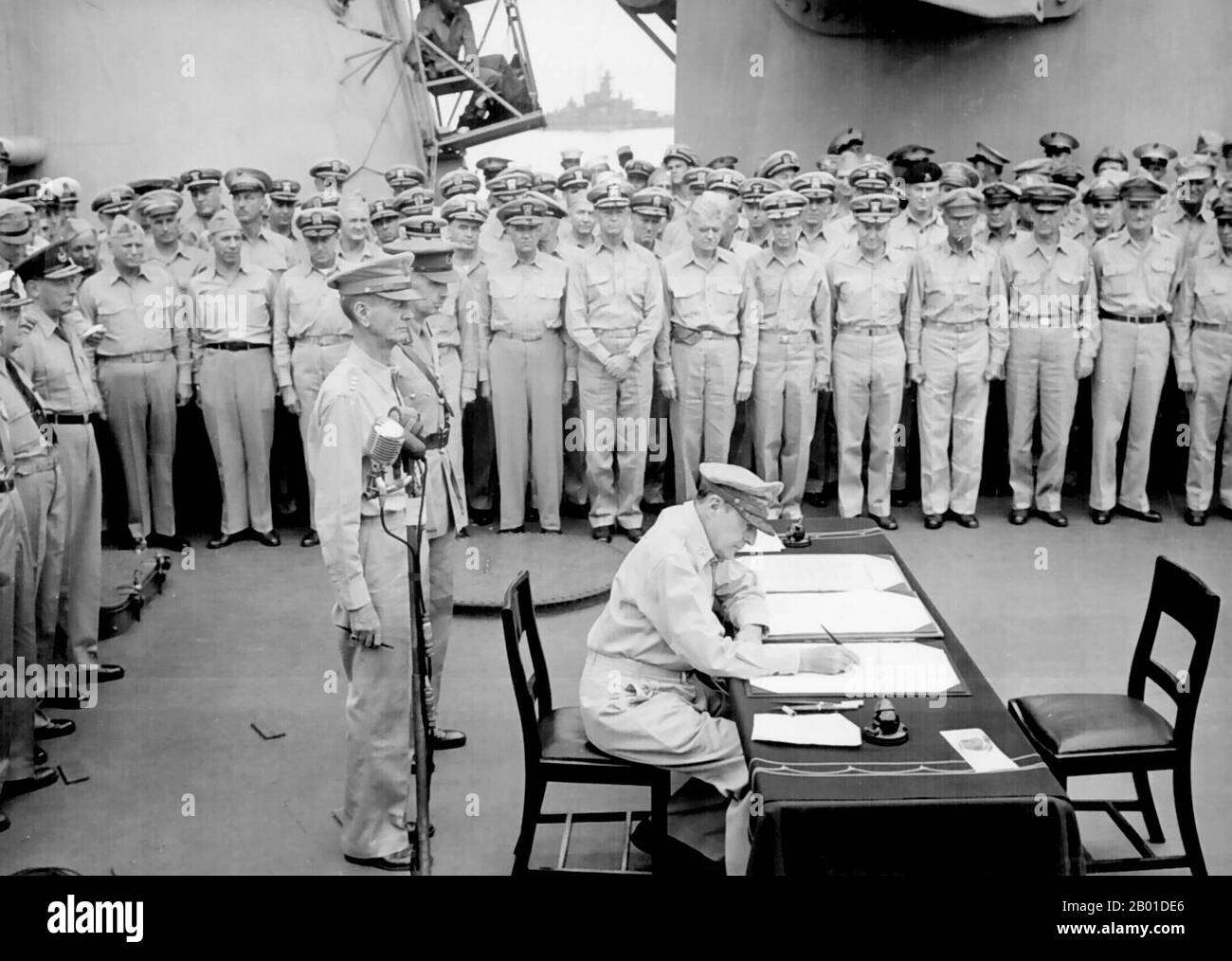 États-Unis/Japon: Le général Douglas MacArthur signe l'instrument japonais de reddition, USS Missouri, baie de Tokyo, 2 septembre 1945. Le général Douglas MacArthur signe comme commandant suprême des alliés lors des cérémonies officielles de remise sur l'USS Missouri dans la baie de Tokyo. Derrière le général MacArthur se trouvent le Lieutenant général Jonathan Wainwright et le Lieutenant général A. E. Percival. Sur 28 août, l'occupation du Japon a commencé. La cérémonie de remise a eu lieu sur 2 septembre à bord de l'USS Missouri, au cours de laquelle des représentants du gouvernement japonais ont signé l'instrument japonais de reddition, mettant fin à la Seconde Guerre mondiale Banque D'Images