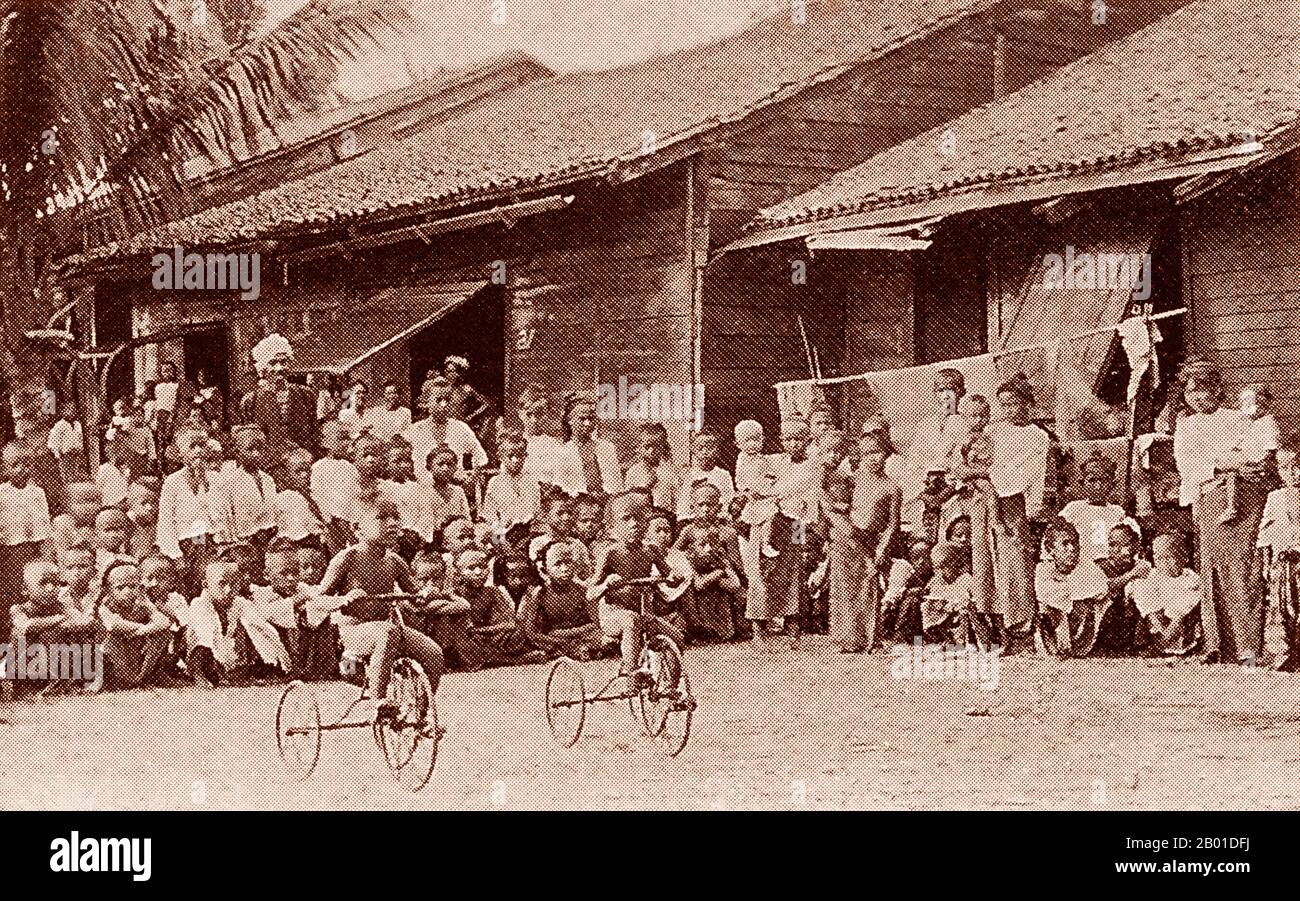 Birmanie : course cycliste pour enfants dans un village birman, vers 1892-1896. La conquête britannique de la Birmanie a commencé en 1824 en réponse à une tentative birmane d'envahir l'Inde. En 1886, et après deux autres guerres, la Grande-Bretagne avait incorporé tout le pays dans le Raj britannique. Pour stimuler le commerce et faciliter les changements, les Britanniques ont fait venir des Indiens et des Chinois, qui ont rapidement déplacé les Birmans dans les zones urbaines. À ce jour, Rangoon et Mandalay ont de grandes populations indiennes ethniques. Des chemins de fer et des écoles ont été construits, ainsi qu'un grand nombre de prisons, dont la tristement célèbre prison d'Insein. Banque D'Images