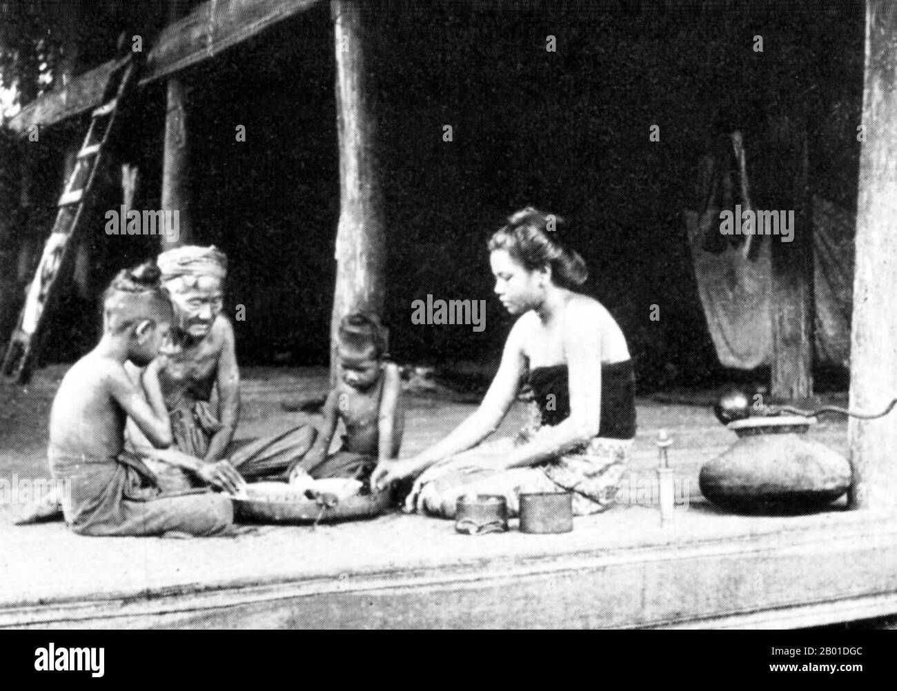 Birmanie : un dîner familial birman, vers 1892-1896. La conquête britannique de la Birmanie a commencé en 1824 en réponse à une tentative birmane d'envahir l'Inde. En 1886, et après deux autres guerres, la Grande-Bretagne avait incorporé tout le pays dans le Raj britannique. Pour stimuler le commerce et faciliter les changements, les Britanniques ont fait venir des Indiens et des Chinois, qui ont rapidement déplacé les Birmans dans les zones urbaines. À ce jour, Rangoon et Mandalay ont de grandes populations indiennes ethniques. Des chemins de fer et des écoles ont été construits, ainsi qu'un grand nombre de prisons, dont la tristement célèbre prison d'Insein. Banque D'Images