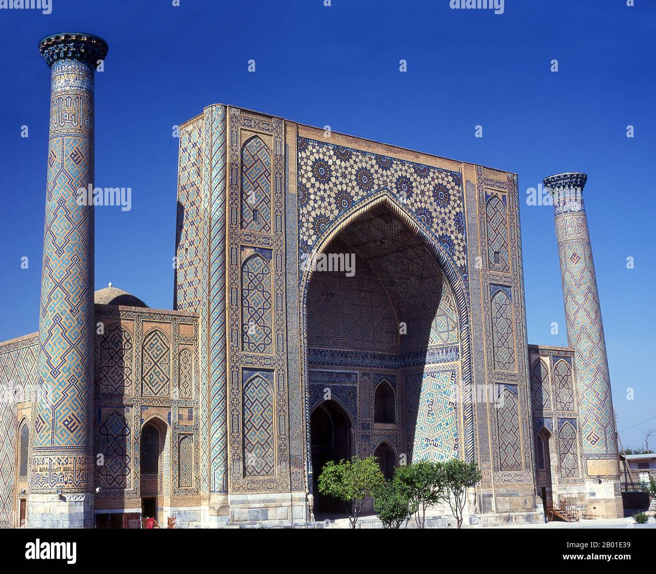 Ouzbékistan: La façade principale d'Ulug Beg Madrassa, le Registan, Samarkand. Le Registan contient trois madrasahs (écoles), le Madrasa d'Ulugh (1417-1420), le Madrasa de Tilya-Kori (1646-1660) et le Madrasa de Sher-Dor (1619-1636). Le Madrasah Beg d'Ulugh a son portail imposant avec l'arche de lancet face à la place. Les coins sont flanqués par les minarets bien proportionnés. Le panneau en mosaïque au-dessus de l'arche d'entrée est décoré d'ornements géométriques stylisés. La cour en forme de carré comprend une mosquée, des salles de conférence et est bordée par les cellules du dortoir où vivaient les étudiants. Banque D'Images