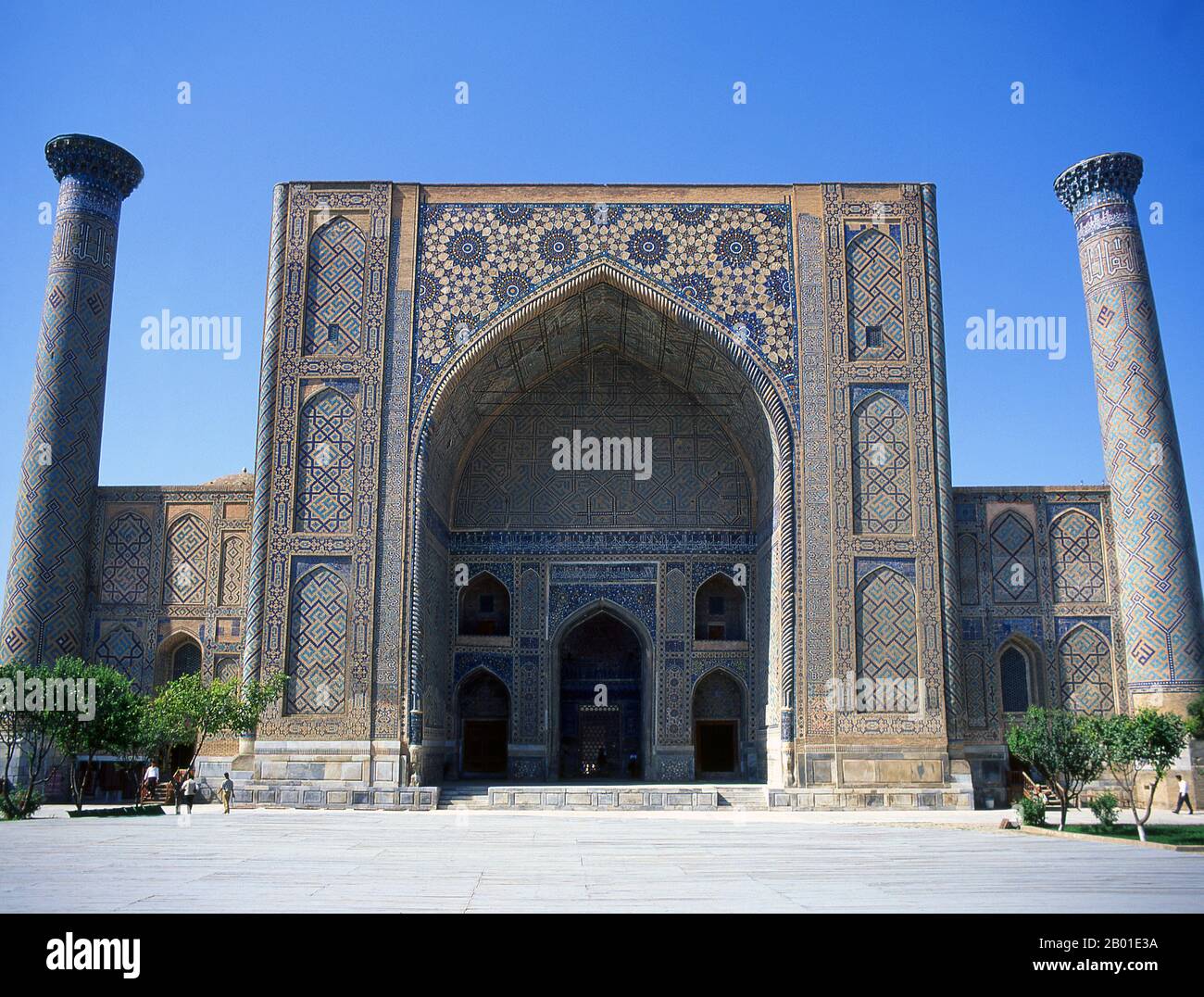 Ouzbékistan: La façade principale d'Ulug Beg Madrassa, le Registan, Samarkand. Le Registan contient trois madrasahs (écoles), le Madrasa d'Ulugh (1417-1420), le Madrasa de Tilya-Kori (1646-1660) et le Madrasa de Sher-Dor (1619-1636). Le Madrasah Beg d'Ulugh a son portail imposant avec l'arche de lancet face à la place. Les coins sont flanqués par les minarets bien proportionnés. Le panneau en mosaïque au-dessus de l'arche d'entrée est décoré d'ornements géométriques stylisés. La cour en forme de carré comprend une mosquée, des salles de conférence et est bordée par les cellules du dortoir où vivaient les étudiants. Banque D'Images