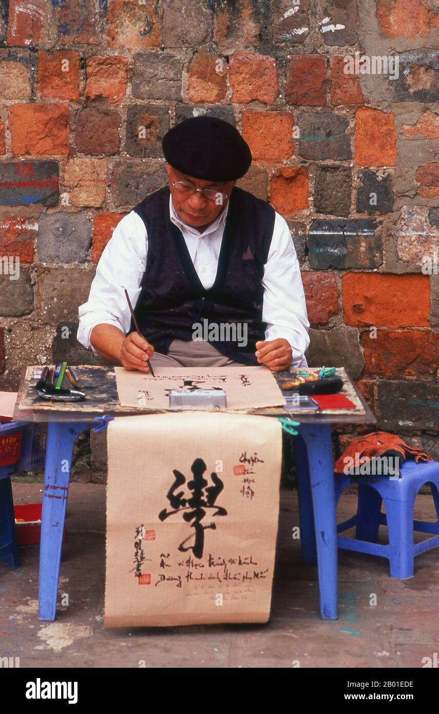 Vietnam : artiste calligraphique près du Temple de la Littérature, Hanoï. La calligraphie d'Asie de l'est est une forme de calligraphie largement pratiquée et vénérée dans la Sinosphère. Cela inclut le plus souvent la Chine, le Japon, la Corée et le Vietnam. La tradition calligraphique de l'Asie de l'est est originaire et développée de Chine. Il y a une normalisation générale des différents styles de calligraphie dans cette tradition. La calligraphie d'Asie de l'est et la peinture à l'encre et au lavage sont étroitement liées, depuis accompli en utilisant des outils et des techniques similaires. Banque D'Images