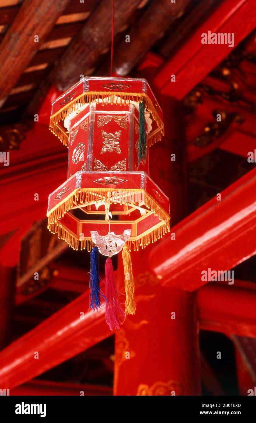 Vietnam : lanterne dans la Grande Maison des cérémonies, Temple de la Littérature (Van Mieu), Hanoï. Le Temple de la Littérature ou Van Mieu est l’un des plus grands trésors culturels du Vietnam. Fondé en 1070 par le roi Ly Thanh Tong du début de la dynastie Ly, le temple était à l'origine dédié à la fois à Concius et à Chu Cong, un membre de la famille royale chinoise reconnu comme étant à l'origine de nombreux enseignements que Confucius a développés cinq cents ans plus tard. Le site a été sélectionné par les géomancres de la dynastie Ly pour se tenir en harmonie avec le temple taoïste Bich Cau et la pagode bouddhiste One Pillar. Banque D'Images