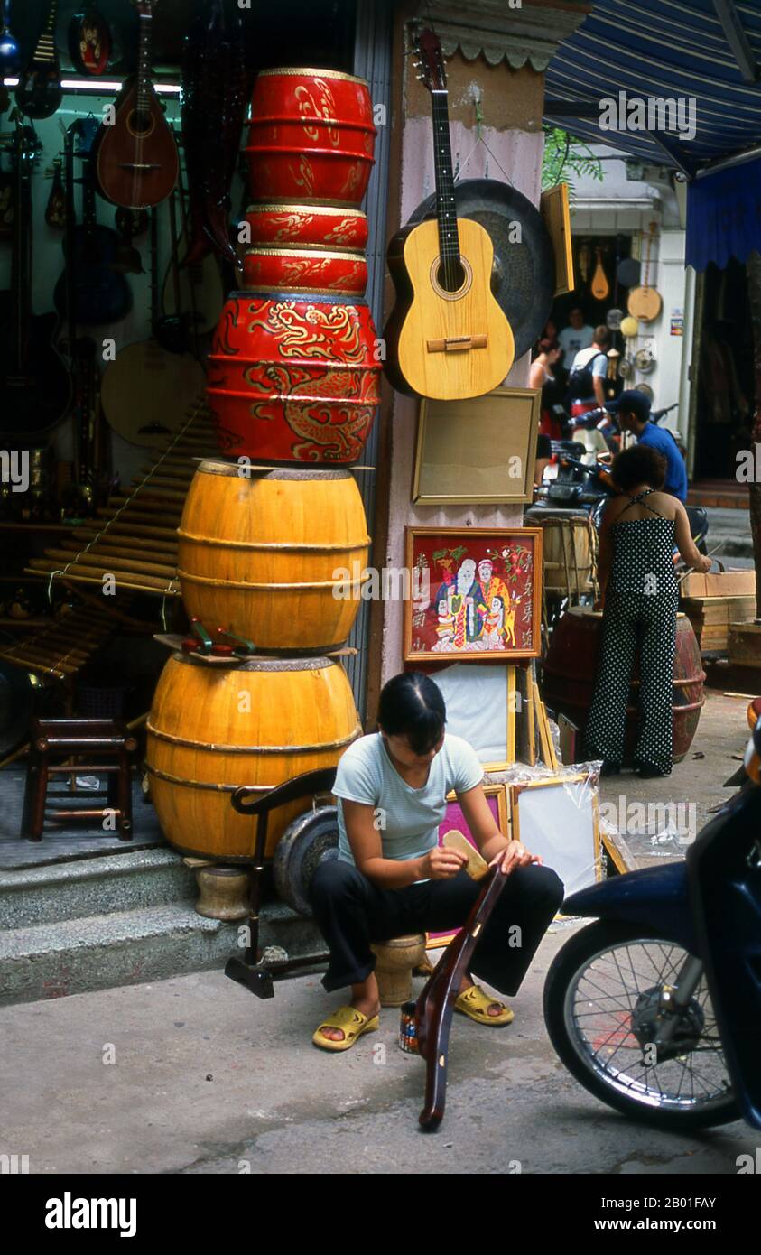 Vietnam: Instruments de musique à vendre dans le Vieux quartier, Hanoi. Le vieux quartier de Hanoi se trouve immédiatement au nord du lac Ho Hoan Kiem. Il est plus connu localement sous le nom de Bam Sau Pho Phuong ou les «trente six rues». 'Phuong' signifie une guilde commerciale, et la plupart des rues commencent par le mot 'Hang' signifiant marchandise. Cette partie ancienne de la ville a longtemps été associée au commerce, et elle le reste encore beaucoup aujourd'hui. Banque D'Images