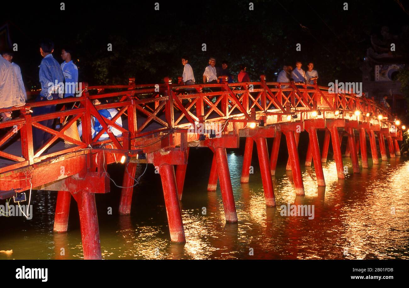 Vietnam: Le rouge peint le pont Huc (Rising Sun ou Sunbeam Bridge) menant à Den Ngoc son ou Jade Mountain Temple, Hoan Kiem Lake, Hanoi. Ho Hoan Kiem signifie «Lac de l'épée restaurée», un plan d'eau qui se trouve au coeur de Hanoï. Jusqu'au 15th siècle, on l'appelait Luc Thuy ou «eau verte». La légende dit que pendant l'occupation Ming (1407-28), le général le Loi a été présenté avec une épée magique par une tortue divine qui vivait dans les eaux. Avec l'aide de cette épée, le Loi expulsa les Chinois du nord du Vietnam et s'établit comme l'empereur le Thai à. Banque D'Images