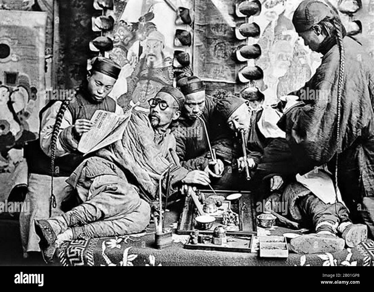 Chine : photo posée d'un groupe de fumeurs d'opium à Canton, carte stéréovisuelle, v. 1900. Une image de studio illustrant une vue occidentale contemporaine de la Chine, y compris la fumée de l'opium et les files d'attente de la dynastie Qing. Banque D'Images