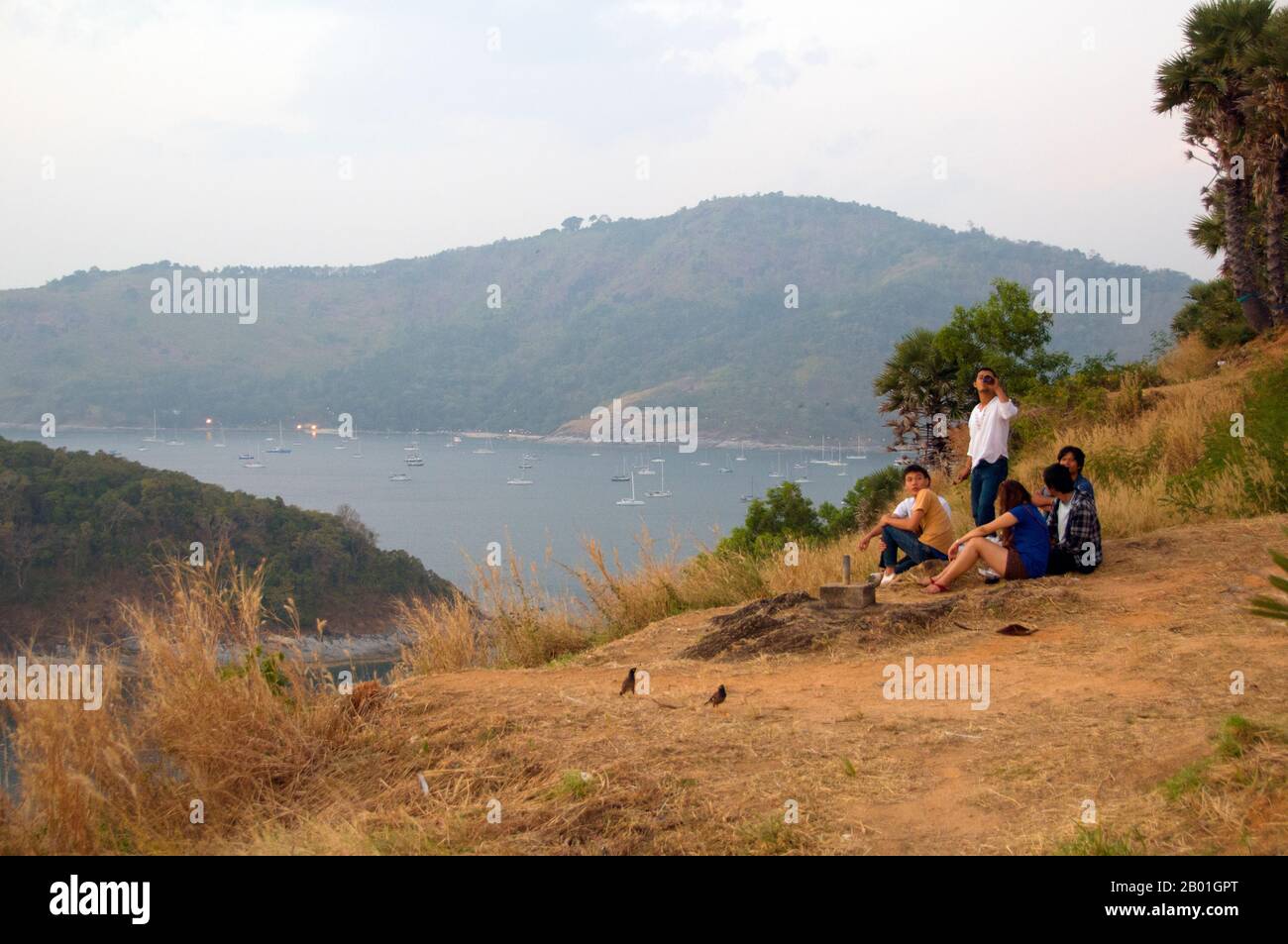 Thaïlande : regarder le coucher du soleil à Laem Phromthep (Cap Phromthep), Phuket. Phuket, à 810 km2 la plus grande île de Thaïlande, se trouve dans la mer d'Andaman juste au large de la côte de la province de Phang-nga. Relié au continent par une large chaussée, il est devenu la station balnéaire la plus luxueuse et exquise de Thaïlande. Au cours des siècles passés Phuket était un important poste de traite sur la rive orientale du golfe du Bengale, traitant de la navigation et traitant avec les marins des mondes arabe et malais, de l'Inde, du Myanmar, de la Chine et, bien sûr, Siam. Au 16e siècle, l'île était également bien connue des Européens. Banque D'Images