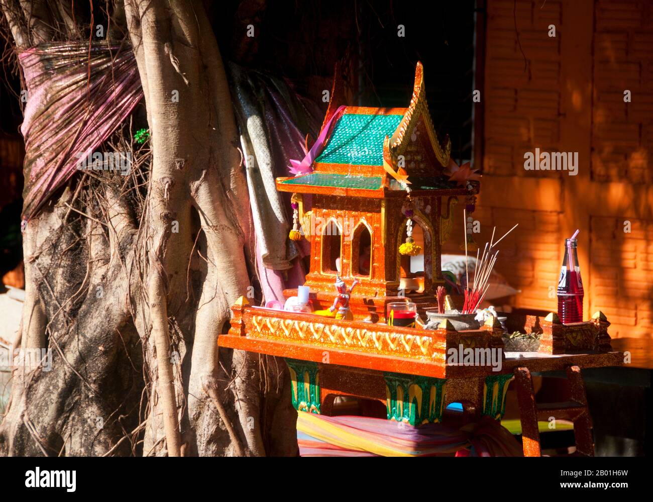 Thaïlande : Maison des esprits, Trang, province de Trang. Beaucoup de thaïlandais croient que chaque maison devrait avoir sa propre maison d'esprit prévoyant le bien-être de l'esprit de la localité. Ceux-ci peuvent être n'importe où dans le jardin (même, dans les grandes villes, sur le toit), avec la condition importante que l'ombre de l'habitation humaine ne devrait jamais tomber sur la maison de l'esprit, la maison du propriétaire original et véritable de la terre - le chao thii. Naturellement, cette croyance s'étend aux magasins et au commerce ainsi, avec un nary une entreprise en Thaïlande n'ayant pas au moins une ou même deux maisons d'esprit. Banque D'Images