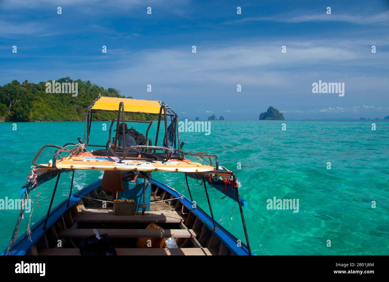 Thaïlande : batelier et mer turquoise, Ko Kradan, province de Trang. Ko Kradan se trouve à 13 km (8 miles) au sud de la jetée Pak Meng de Trang et est juste l'une des perles de la mer d'Andaman qui se trouvent au large de la côte sud-ouest de Trang. La province de Trang dépendait de l'extraction de l'étain jusqu'à ce que les premiers plants de caoutchouc soient introduits en Thaïlande vers 1901 - une partie d'un long voyage depuis l'Amérique du Sud via les États malais voisins. Le caoutchouc, l'huile de palme et la pêche sont les piliers de l'économie de la province. Le tourisme a un impact croissant alors que la côte et les îles Anadaman de Trang sont de plus en plus développées et popularisées. Banque D'Images