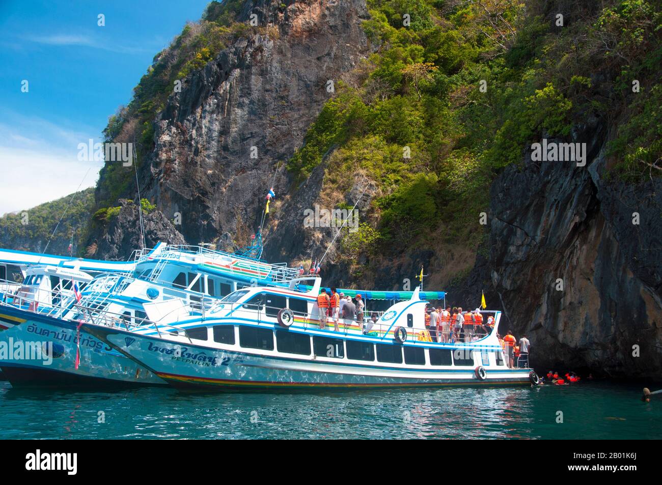 Thaïlande : bateaux d'excursion à Tham Morakot (grotte d'émeraude), Ko Muk, province de Trang. Ko Muk ou «Pearl Island» se trouve à 13 km (8 miles) au sud de Trang's Pak Meng Pier. Jusqu'à assez récemment, une destination reculée de Backpacker avec une petite population résidente de Chao Lae «Sea Gypsies», Ko Muk se développe rapidement pour devenir une destination plus haut de gamme. Tham Morakot ou « Emerald Cave » est une attraction locale majeure. Les visiteurs doivent nager environ 75 mètres (240 pieds) à travers une caverne remplie d'eau à marée haute, une partie de la baignade étant dans l'obscurité virtuelle, pour atteindre un hong ou un lagon rempli de mer. Banque D'Images