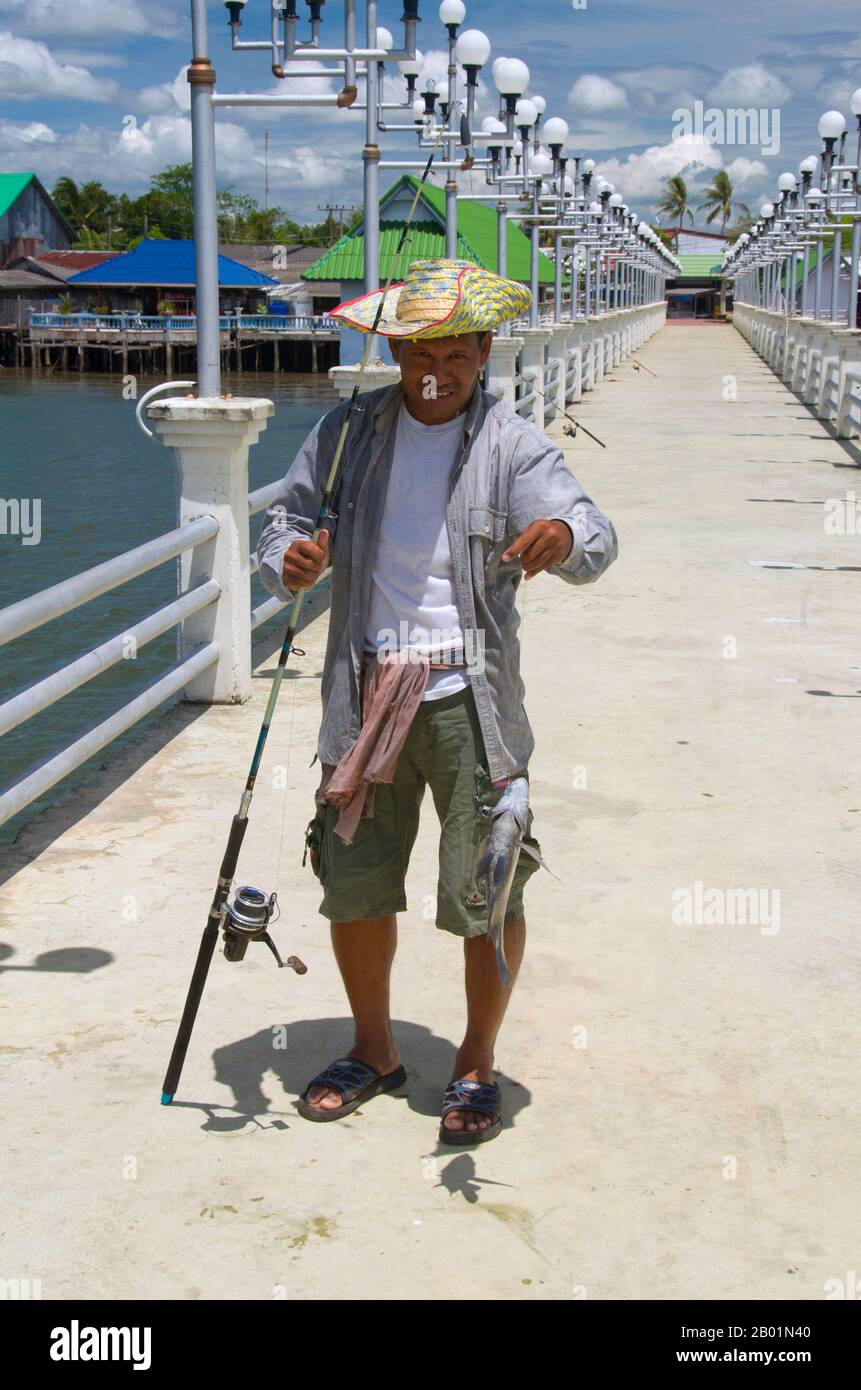 Thaïlande : pêcheur à la jetée Ban Laem Kruat, point de ferry pour les îles de Ko si Boya et Ko Jam, côte de Krabi. La province de Krabi est composée de plus de 5 000 km2 de collines couvertes de jungle et d'affleurements karstiques pointus et déchiquetés, ainsi que de plus de 100 km de côtes luxuriantes et immaculées et d'environ 200 îles dans la mer d'Andaman voisine. Environ 40 % de la population provinciale est musulmane, le reste étant majoritairement bouddhiste. Ceci est une indication claire que Krabi se trouve à cheval sur la ligne de démarcation invisible entre la Thaïlande bouddhiste et les quatre provinces du sud. Banque D'Images