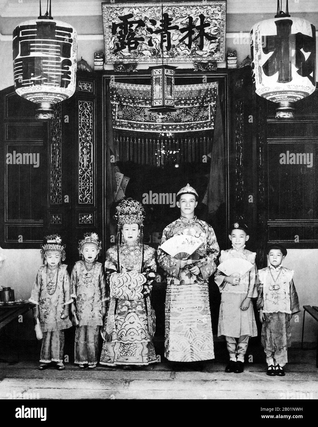 Malaisie/Singapour : une mariée Penang pose pour leur photographie de mariage devant le magasin familial, début du 20e siècle. Peranakan Chinese et Baba-Nyonya sont des termes utilisés pour désigner les descendants des immigrants chinois de la fin des 15e et 16e siècles dans l'archipel malais-indonésien de Nusantara pendant l'ère coloniale. Les membres de cette communauté en Malaisie s'identifient comme 'Nyonya-Baba' ou 'Baba-Nyonya'. Nyonya est le terme pour les femelles et Baba pour les mâles. Elle s ' applique en particulier aux populations ethniques chinoises des établissements britanniques du détroit de Malaisie. Banque D'Images