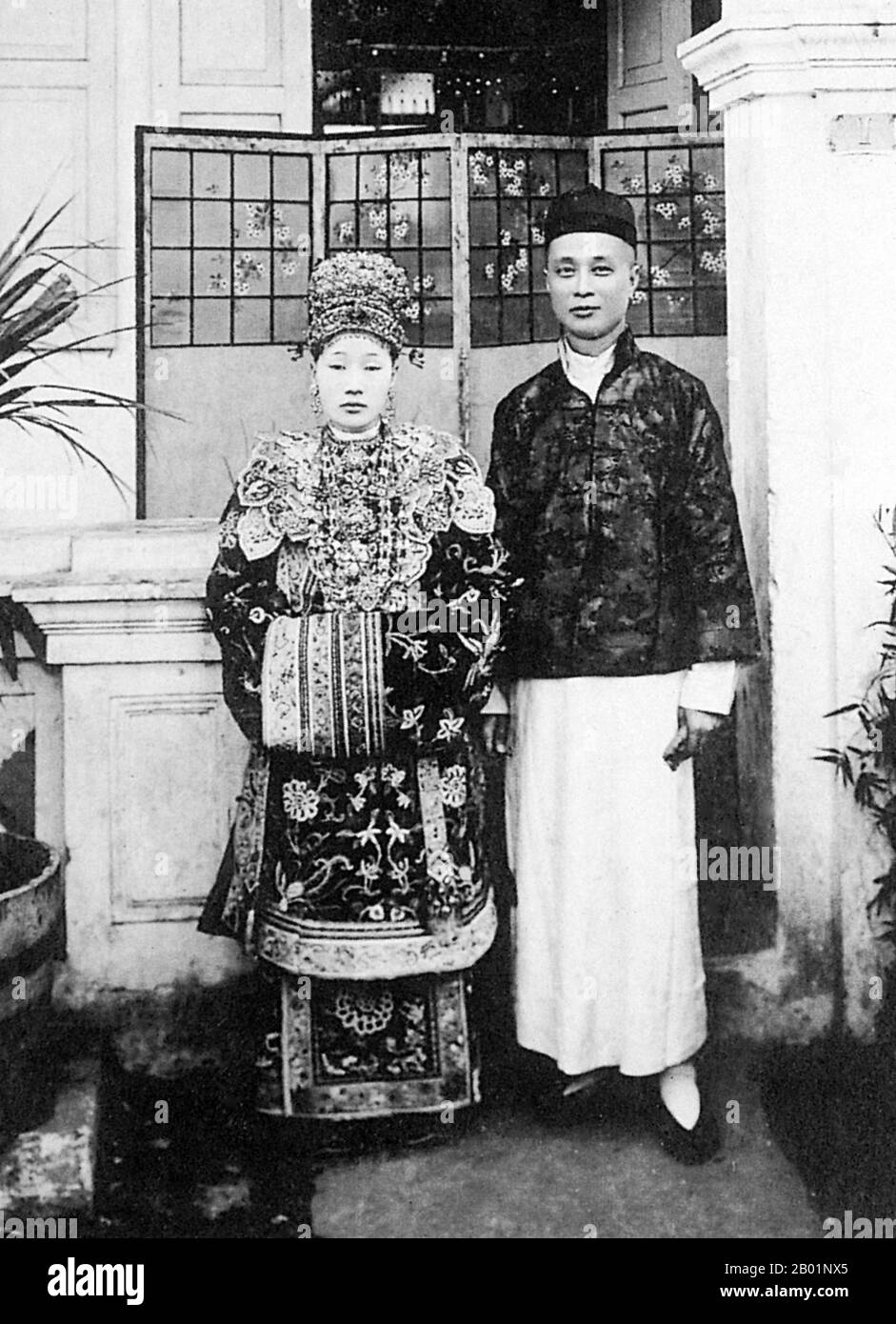 Malaisie : mariée et marié Peranakan, Melaka (Malacca), début du 20e siècle. Peranakan Chinese et Baba-Nyonya sont des termes utilisés pour désigner les descendants des immigrants chinois de la fin des 15e et 16e siècles dans l'archipel malais-indonésien de Nusantara pendant l'ère coloniale. Les membres de cette communauté en Malaisie s'identifient comme 'Nyonya-Baba' ou 'Baba-Nyonya'. Nyonya est le terme pour les femelles et Baba pour les mâles. Elle s ' applique en particulier aux populations chinoises de souche des établissements britanniques du détroit de Malaisie et de l ' île de Java contrôlée par les Néerlandais et d ' autres localités. Banque D'Images