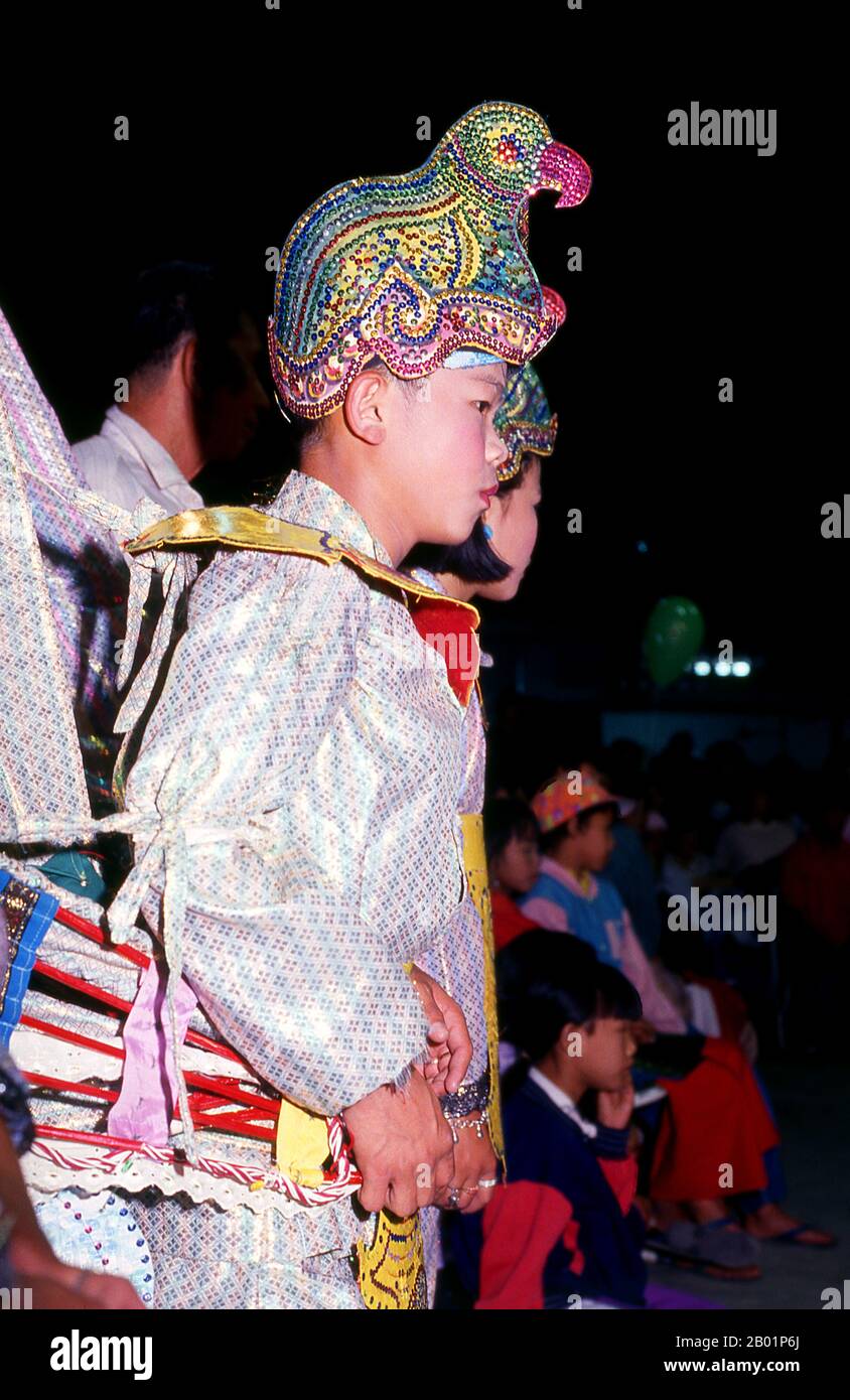 Thaïlande : un danseur Shan (Tai Yai) attend son signal à la veille du festival Poy sang long, Wat Pa Pao (temple Shan), Chiang Mai, nord de la Thaïlande. Wat Pa Pao est un temple bouddhiste Shan (Tai Yai) qui sert de centre à la communauté Shan de Chiang Mai. Il a été construit à la fin du 19e siècle. Une fois par an, Wat Pa Pao accueille les luk kaeo, ou « fils de cristal » - de jeunes garçons Shan sur le point d'être ordonnés dans le monkhood bouddhiste. Beaucoup de ces novices se rendent à Chiang Mai depuis les communautés Shan environnantes de Mae Cham, Mae Rim, Chiang Dao et Fang. Cette cérémonie Shan annuelle est appelée Poy sang long. Banque D'Images