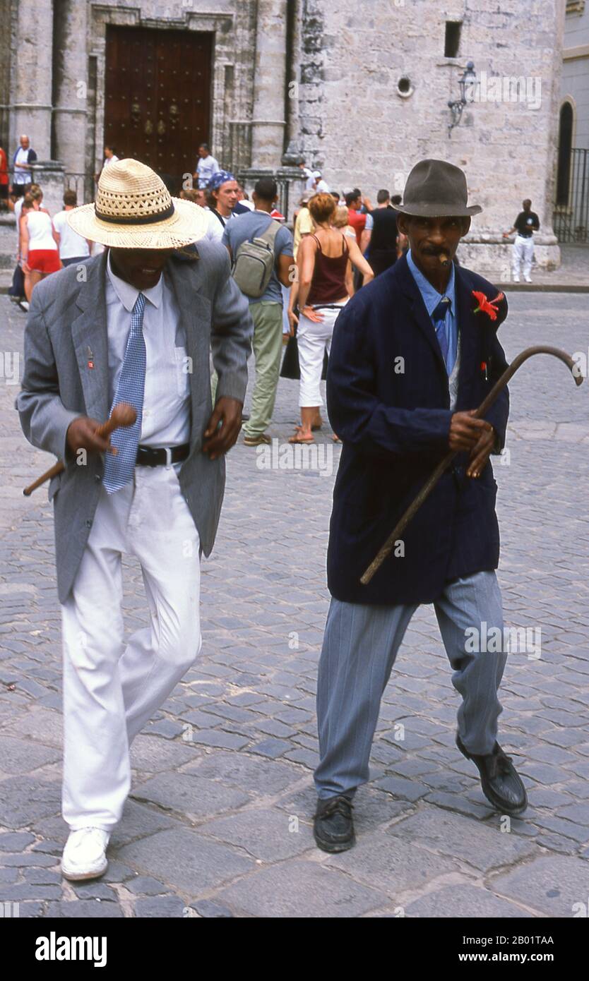Cuba : les dresseurs de rue Natty dansent les claquettes sur la Plaza de la Catedral, Vieille Havane. Plaza de la Catedral est l'une des places de la Vieille Havane, cette zone ouverte pavée (piétons seulement) est entourée de beaux bâtiments et abrite le plus coloré de tous les gens de la rue et artistes de la performance de la Habana Vieja. Ils vont des prêtresses Santería aux danseuses de rue pointues, en passant par les filles fleuries et les rastafariens. La Catedral de la Habana, baroque datant de 1777, domine la place et est officiellement appelée Catedral de la Virgen María de la Concepción Immaculada. Banque D'Images