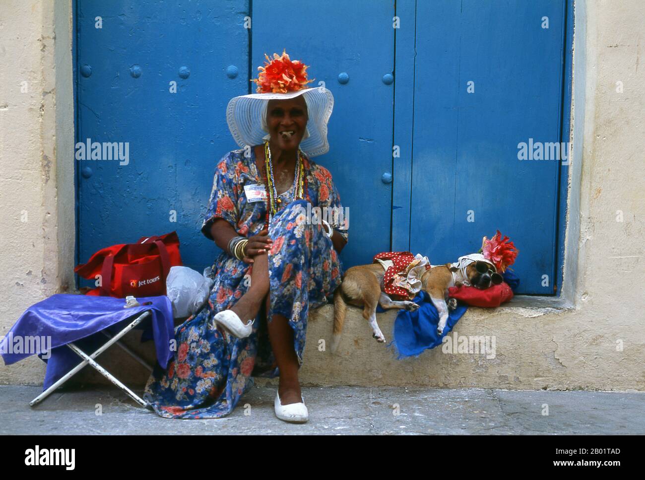 Cuba : une animatrice de rue avec son chien sur la Plaza de la Catedral, Vieille Havane. Plaza de la Catedral est l'une des places de la Vieille Havane, cette zone ouverte pavée (piétons seulement) est entourée de beaux bâtiments et abrite le plus coloré de tous les gens de la rue et artistes de la performance de la Habana Vieja. Ils vont des prêtresses Santería aux danseuses de rue pointues, en passant par les filles fleuries et les rastafariens. La Catedral de la Habana, baroque datant de 1777, domine la place et est officiellement la Catedral de la Virgen María de la Concepción Immaculada. Banque D'Images