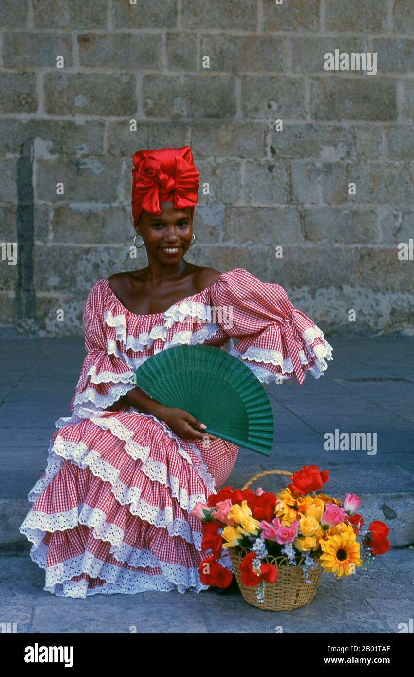Cuba : Belle femme mulatta sur la Plaza de la Catedral, Vieille Havane. Plaza de la Catedral est l'une des places de la Vieille Havane, cette zone ouverte pavée (piétons seulement) est entourée de beaux bâtiments et abrite le plus coloré de tous les gens de la rue et artistes de la performance de la Habana Vieja. Ils vont des prêtresses Santería aux danseuses de rue pointues, en passant par les filles fleuries et les rastafariens. La cathédrale baroque de la Habana, de 1777, domine la place. Officiellement la Catedral de la Virgen María de la Concepción Immaculada, les portes en bois avec laiton sont particulièrement impressionnantes. Banque D'Images