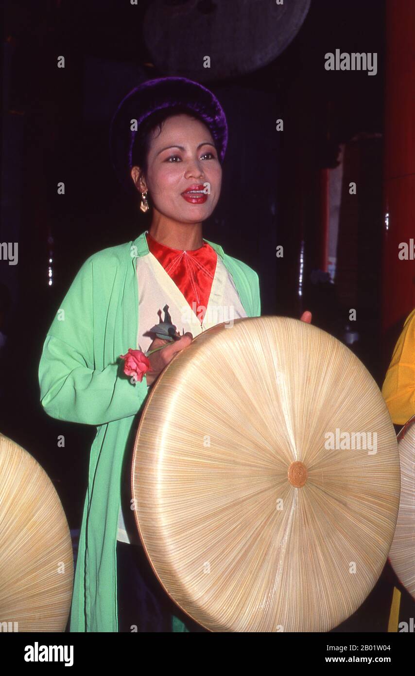 Vietnam : chanteuse avec un orchestre traditionnel vietnamien au Van Mieu (le Temple de la littérature), Hanoi. Le Vietnam a une longue tradition de musique et de théâtre qui combine influences indigènes et étrangères. Les premiers instruments connus sont les tambours de grenouille de la période Dong son à partir de 250 av. J.-C.. Cela a été suivi par un millénaire d'immersion dans les traditions culturelles chinoises qui reste très visible. En 981, après la réaffirmation de l'indépendance nationale, le roi le Dai Hanh envahit Champa voisin et ramène les danseurs et musiciens de la cour royale dans sa capitale. Banque D'Images