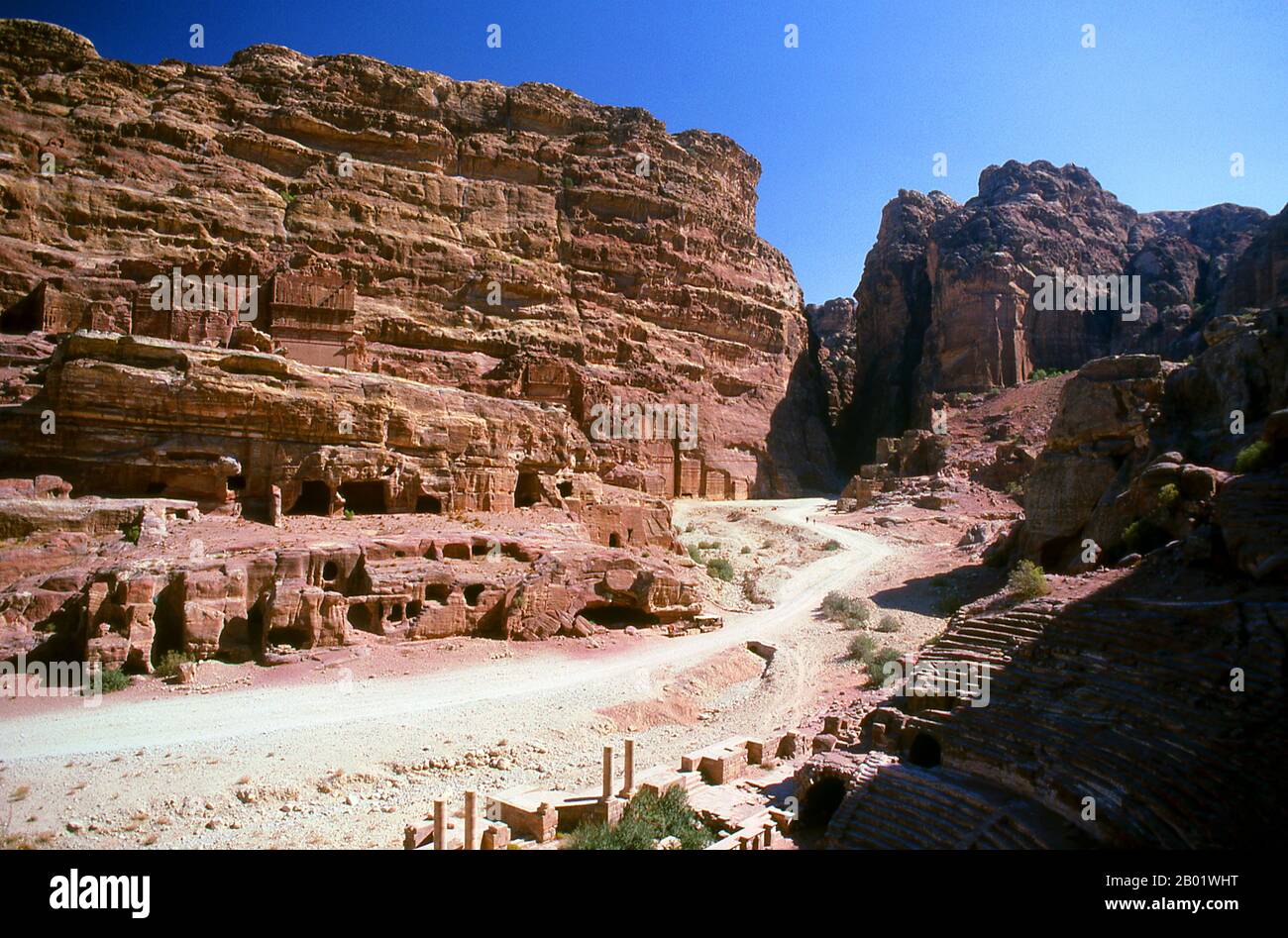 Jordanie : la rue des façades, Petra. Pétra a été établie pour la première fois comme une ville par les Arabes nabatéens au IVe siècle av. J.-C., et doit sa naissance et sa prospérité au fait qu'elle était le seul endroit avec une eau claire et abondante entre les centres commerciaux du Hijaz de la Mecque et Médine, et la Palestine. Creusée directement dans les crêtes de grès nubiennes du désert du sud de la Jordanie, il semble probable que - compte tenu de son excellente position défensive et de ses bonnes réserves d'eau - Petra a été continuellement occupée dès l'époque paléolithique. On pense qu'il est mentionné dans la Bible comme Sela. Banque D'Images