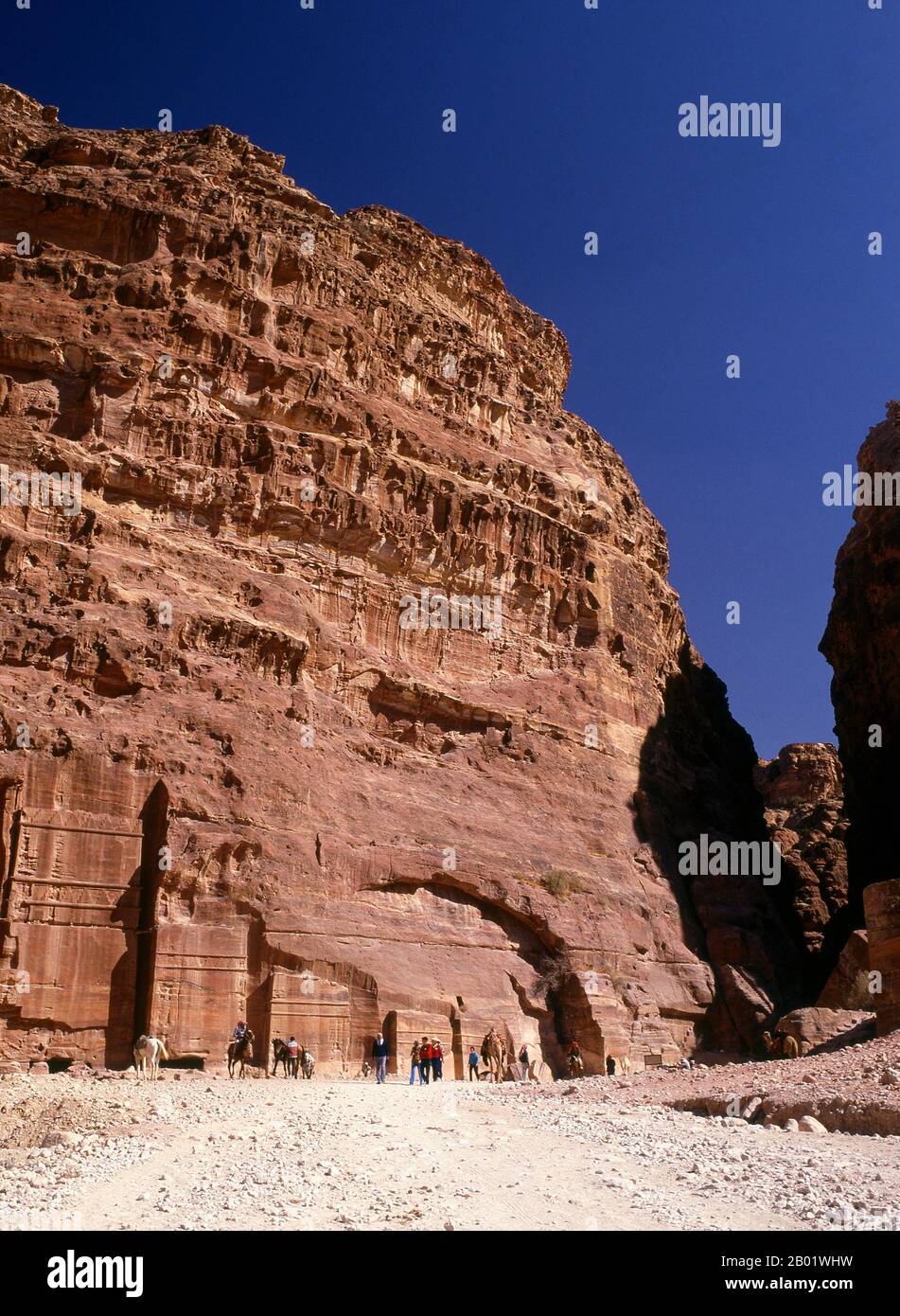 Jordanie : la rue des façades, Petra. Pétra a été établie pour la première fois comme une ville par les Arabes nabatéens au IVe siècle av. J.-C., et doit sa naissance et sa prospérité au fait qu'elle était le seul endroit avec une eau claire et abondante entre les centres commerciaux du Hijaz de la Mecque et Médine, et la Palestine. Creusée directement dans les crêtes de grès nubiennes du désert du sud de la Jordanie, il semble probable que - compte tenu de son excellente position défensive et de ses bonnes réserves d'eau - Petra a été continuellement occupée dès l'époque paléolithique. On pense qu'il est mentionné dans la Bible comme Sela. Banque D'Images