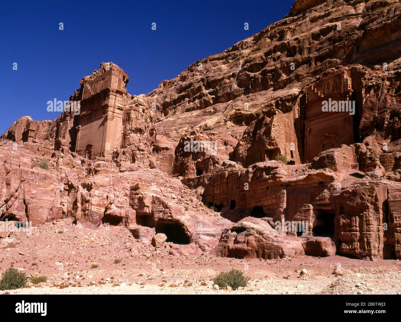 Jordanie : la rue des façades, Petra. Pétra a été établie pour la première fois comme une ville par les Arabes nabatéens au IVe siècle av. J.-C., et doit sa naissance et sa prospérité au fait qu'elle était le seul endroit avec une eau claire et abondante entre les centres commerciaux du Hijaz de la Mecque et Médine, et la Palestine. Creusée directement dans les crêtes de grès nubiennes du désert du sud de la Jordanie, il semble probable que - compte tenu de son excellente position défensive et de ses bonnes réserves d'eau - Petra a été continuellement occupée dès l'époque paléolithique. On pense qu'il est mentionné dans la Bible comme Sela. Banque D'Images