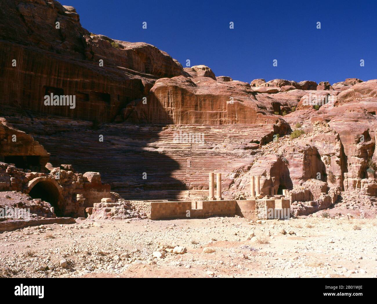 Jordanie : le Théâtre construit au Ier siècle EC, Petra. Pétra a été établie pour la première fois comme une ville par les Arabes nabatéens au IVe siècle av. J.-C., et doit sa naissance et sa prospérité au fait qu'elle était le seul endroit avec une eau claire et abondante entre les centres commerciaux du Hijaz de la Mecque et Médine, et la Palestine. Creusée directement dans les crêtes de grès nubiennes du désert du sud de la Jordanie, il semble probable que - compte tenu de son excellente position défensive et de ses bonnes réserves d'eau - Petra a été continuellement occupée dès l'époque paléolithique. On pense qu'il est mentionné dans la Bible. Banque D'Images