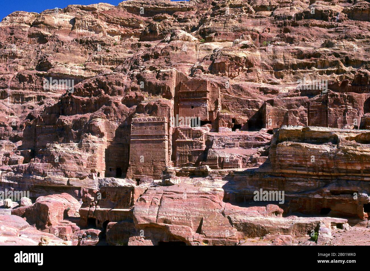 Jordanie : la rue des façades, Petra. Pétra a été établie pour la première fois comme une ville par les Arabes nabatéens au IVe siècle av. J.-C., et doit sa naissance et sa prospérité au fait qu'elle était le seul endroit avec une eau claire et abondante entre les centres commerciaux du Hijaz de la Mecque et Médine, et la Palestine. Creusée directement dans les crêtes de grès nubiennes du désert du sud de la Jordanie, il semble probable que - compte tenu de son excellente position défensive et de ses bonnes réserves d'eau - Petra a été continuellement occupée dès l'époque paléolithique. On pense qu'il est mentionné dans la Bible comme Sela. Banque D'Images