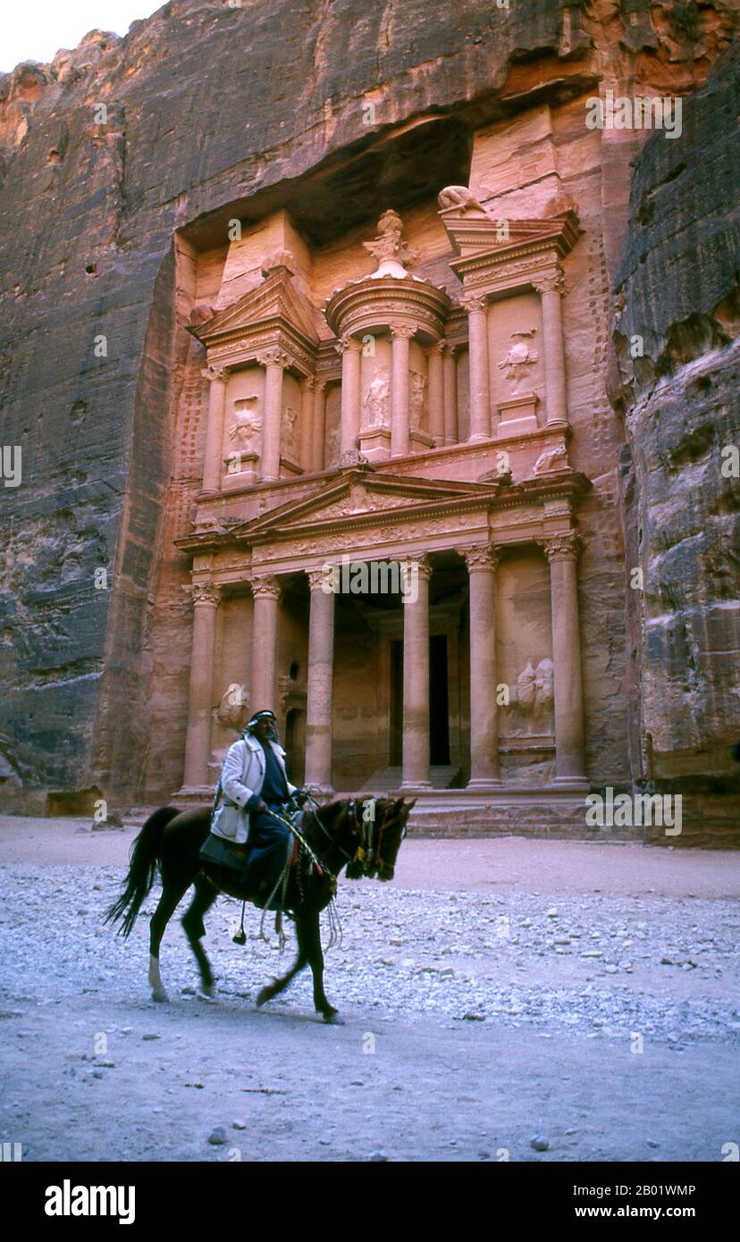 Jordanie : un cavalier arabe devant Al Khazneh (le Trésor), Petra. Al Khazneh ('le Trésor') est l'un des bâtiments les plus élaborés de l'ancienne ville jordanienne de Pétra. Comme la plupart des autres bâtiments de cette ancienne ville, y compris le monastère, cette structure a également été taillée dans une paroi rocheuse en grès. Il a une architecture d'influence grecque classique. Petra a été établie pour la première fois comme une ville par les Arabes nabatéens au IVe siècle av. J.-C., et doit sa naissance et sa prospérité au fait qu'elle était le seul endroit avec une eau claire et abondante entre les centres commerciaux du Hijaz. Banque D'Images