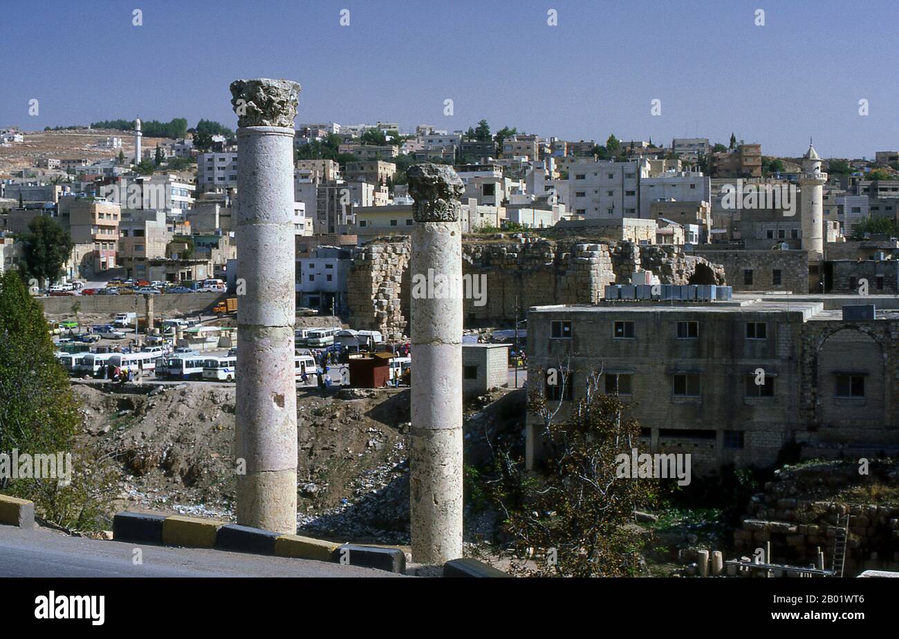 Jordanie : colonnes romaines devant la ville moderne de Jerash. Jerash est le site des ruines de la ville gréco-romaine de Gerasa, également appelée Antioche sur le fleuve d'Or. Jerash est considérée comme l'une des villes romaines les plus importantes et les mieux préservées du proche-Orient. C'était une ville de la Décapole. Des fouilles récentes montrent que Jerash était déjà habité pendant l'âge du bronze (3200-1200 av. J.-C.). Après la conquête romaine en 63 av. J.-C., Jerash et les terres qui l'entourent ont été annexées par la province romaine de Syrie, et ont rejoint plus tard les villes de la Décapole. Banque D'Images