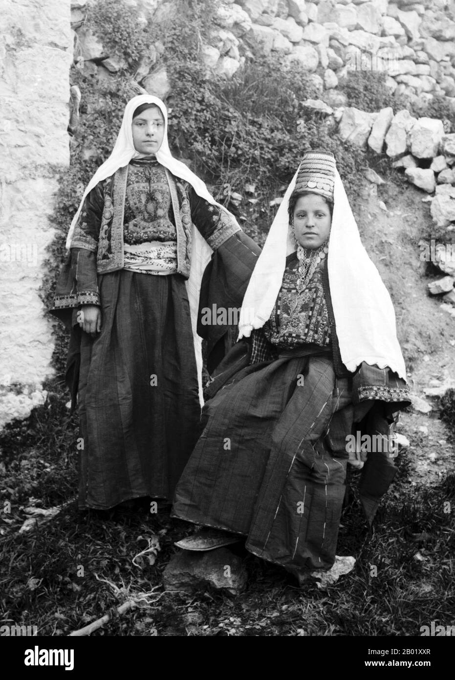 Palestine : deux palestiniennes de Bethléem vêtues de vêtements traditionnels, v. 1920. Palestine est un nom donné à la région géographique entre la mer Méditerranée et le Jourdain. La région est également connue comme la Terre d'Israël, la Terre Sainte et le Levant Sud. En 1832, la Palestine a été conquise par l'Égypte de Muhammad Ali, mais en 1840, la Grande-Bretagne est intervenue et a rendu le contrôle du Levant aux Ottomans en échange de nouvelles capitulations. La fin du XIXe siècle voit le début de l'immigration sioniste et la renaissance de la langue hébraïque. Banque D'Images