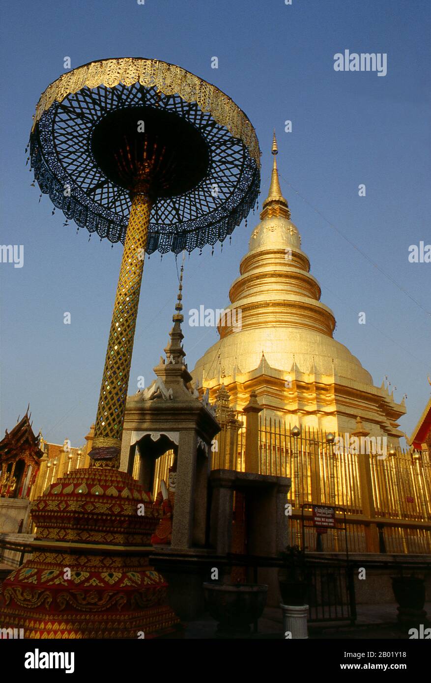 Thaïlande : Wat Phra que le chedi de Haripunchai mesure 46 m de haut et est surmonté d’un parapluie à neuf niveaux composé de 6,5 kg d’or pur, Lamphun, dans le nord de la Thaïlande. Wat Phra That Haripunchai a été fondé en 1044 par le roi Athitayarat de Haripunchai sur le site du palais royal de la reine Chamathewi (Chama Thewi ou Chamadevi). La légende raconte que les quartiers personnels de la reine sont enfermés dans le chedi principal de style LAN Na de 46 mètres de haut, recouvert de plaques de cuivre et surmonté d'un parapluie ou d'un plaid en or. Lamphun était la capitale du petit mais culturellement riche Royaume de mon de Haripunchai. Banque D'Images