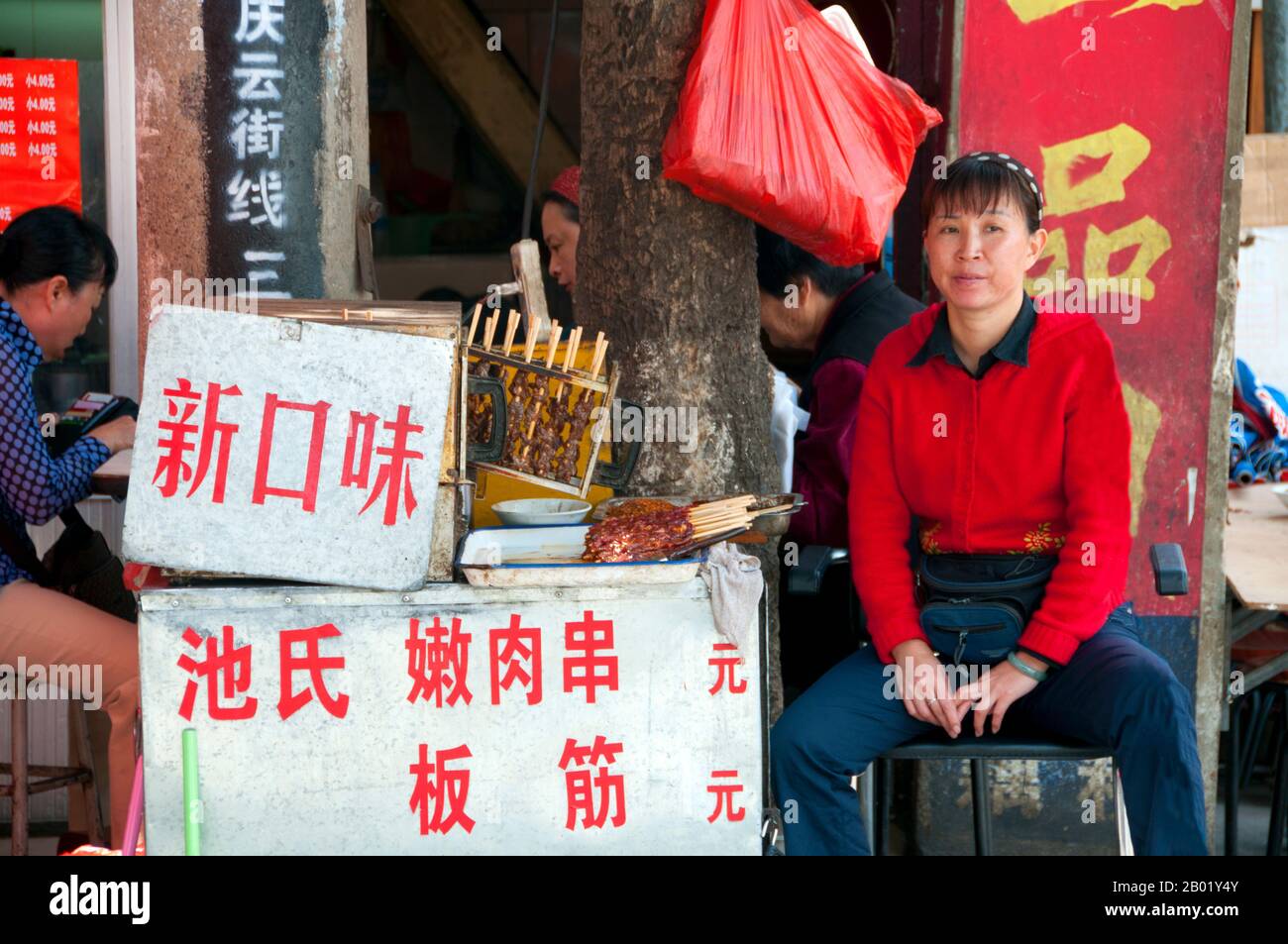 Chine : vendeur de kebab près du marché aux oiseaux et aux fleurs dans le vieux quartier musulman sur la route de Jingxing au large de la route de Zheng Yi, Kunming, province du Yunnan. Construit sur les rives du lac Dian et entouré de montagnes calcaires, Kunming était une importante route commerciale ancienne entre le Tibet, la Chine et l'Asie du Sud-est. La ville, alors appelée Yunnanfu, a souffert des mains du chef rebelle du Wenxiu, le sultan de Dali, qui a attaqué et assiégé la ville à plusieurs reprises entre 1858 et 1868, rasant la plupart des temples bouddhistes de la ville. Banque D'Images