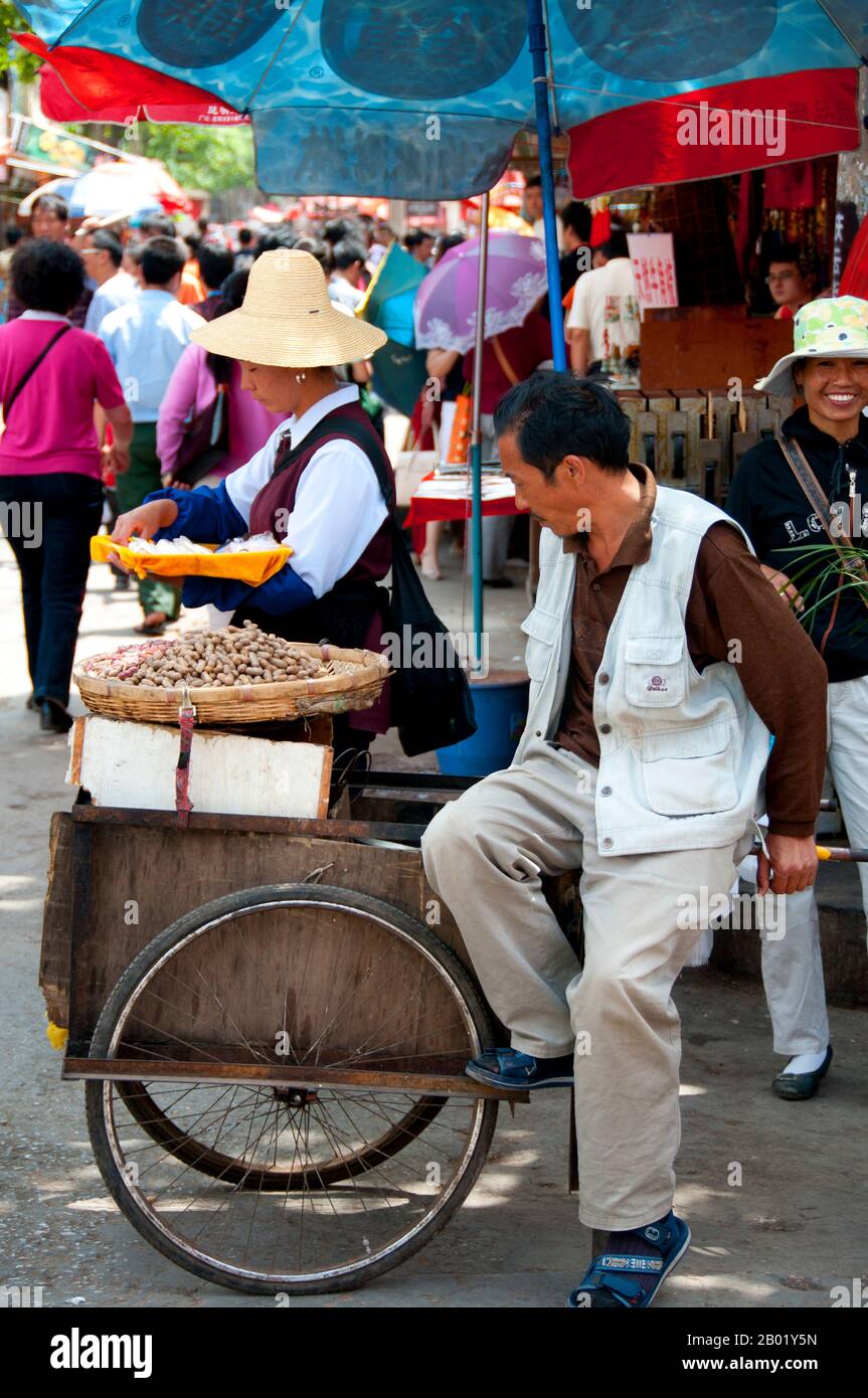 Chine : vendeur d'arachides près du marché aux oiseaux et aux fleurs dans le vieux quartier musulman sur la route de Jingxing au large de la route de Zheng Yi, Kunming, province du Yunnan. Construit sur les rives du lac Dian et entouré de montagnes calcaires, Kunming était une importante route commerciale ancienne entre le Tibet, la Chine et l'Asie du Sud-est. La ville, alors appelée Yunnanfu, a souffert des mains du chef rebelle du Wenxiu, le sultan de Dali, qui a attaqué et assiégé la ville à plusieurs reprises entre 1858 et 1868, rasant la plupart des temples bouddhistes de la ville. Banque D'Images